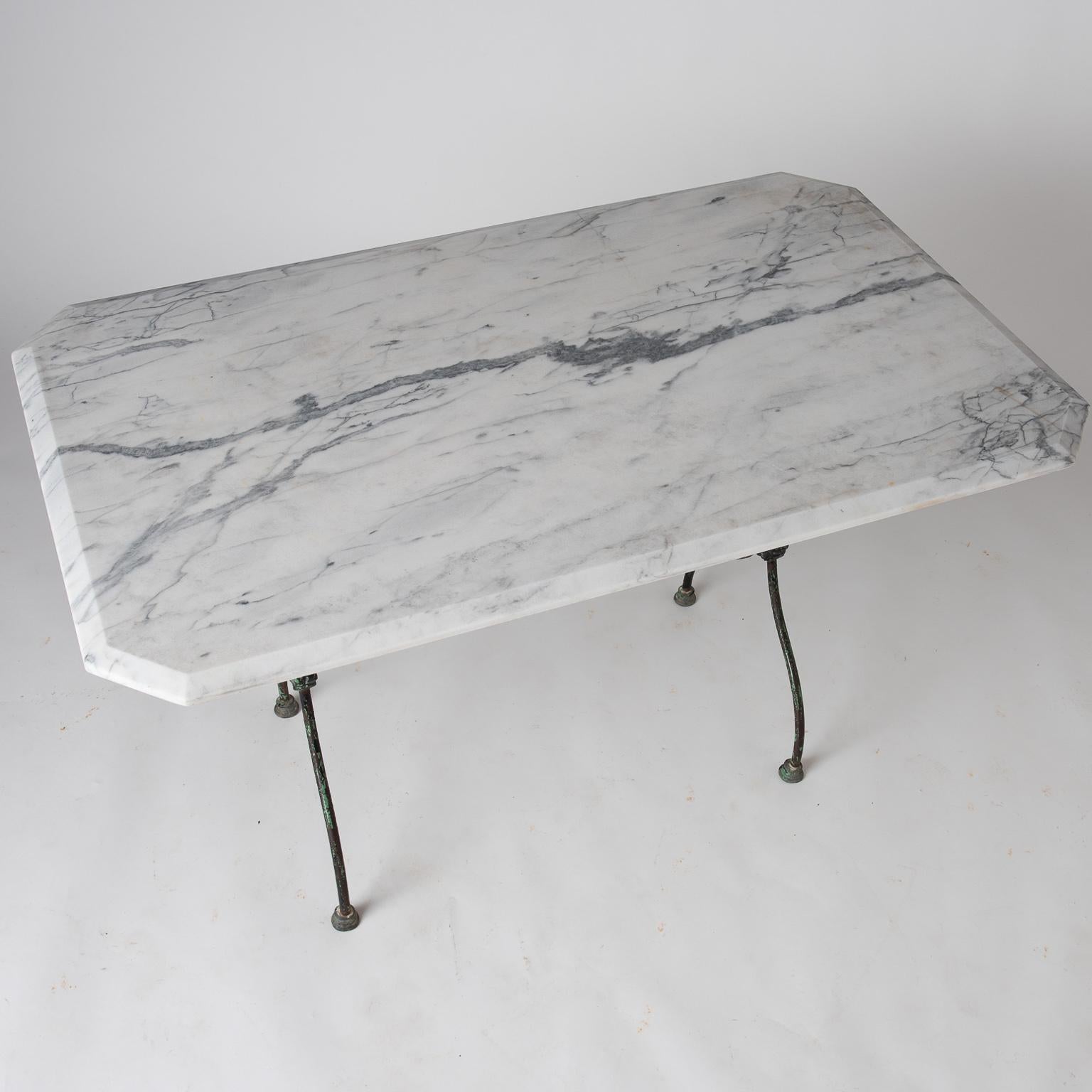 This table has a lovely green painted base retaining the original color and special details, with medallions at each side and pad feet. The large piece of marble with elaborate veining and beveled edges is quite attractive.
  