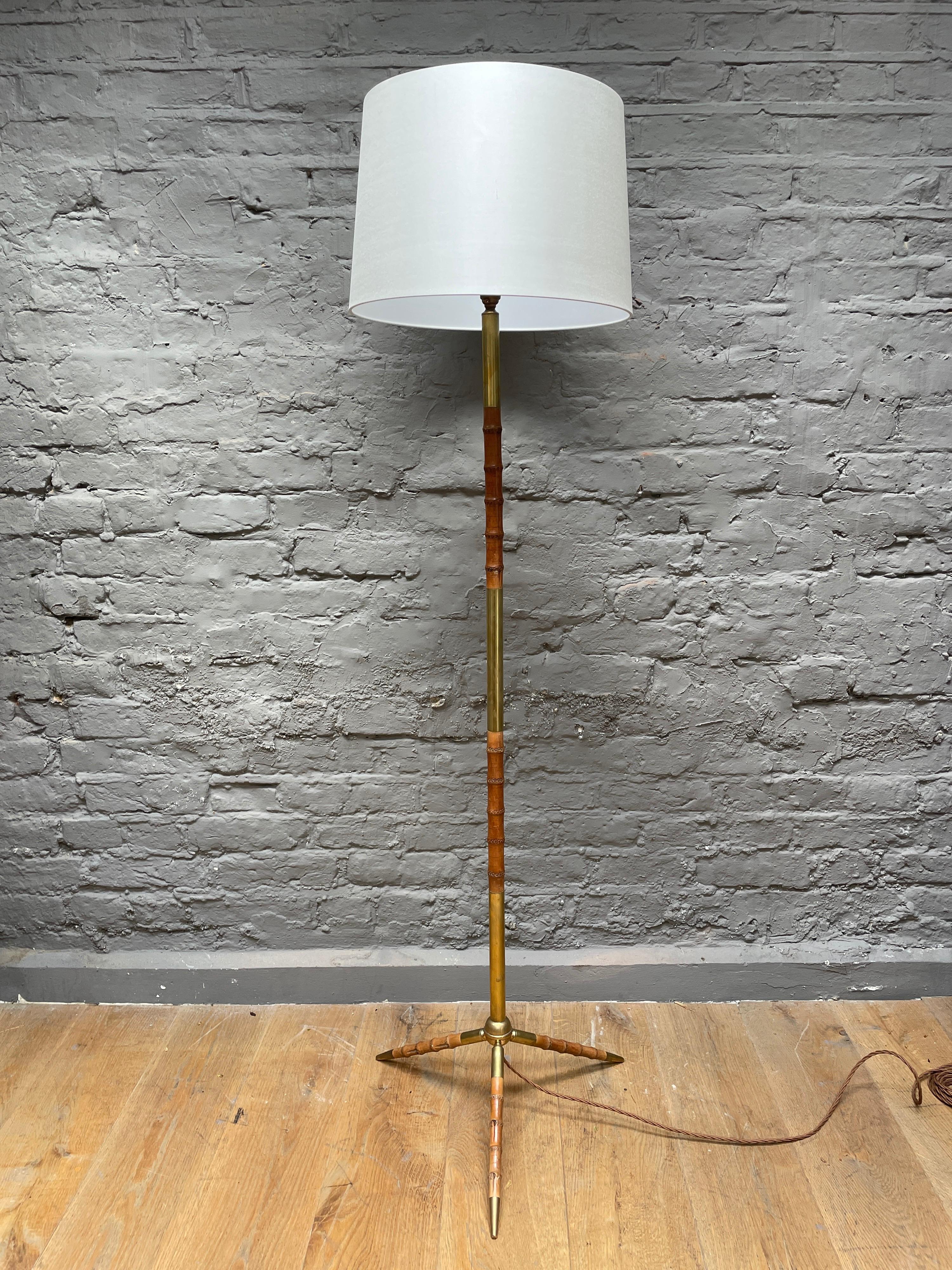 A mid century French tripod floor lamp in brass and leather designed in the faux bamboo taste. A great quality and elegant piece.

Height with shown shade 153cm 

Circa 1950-60.
