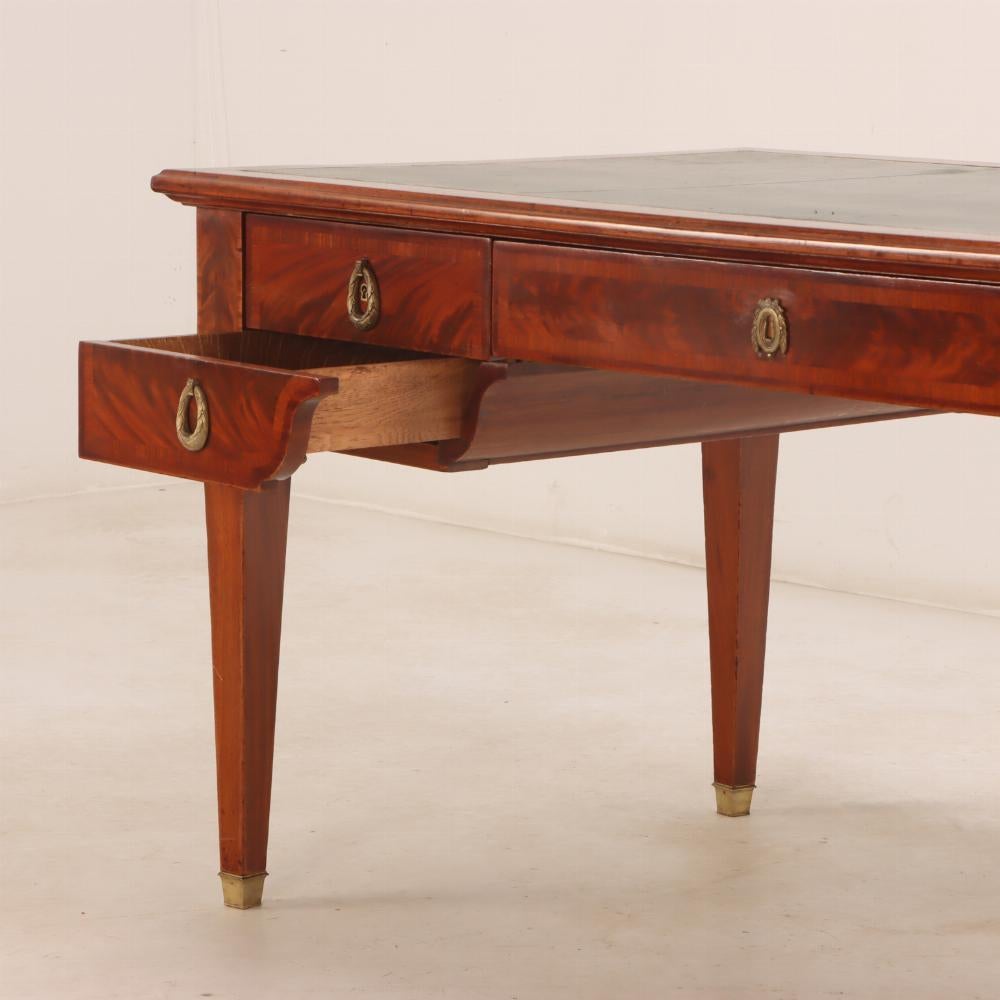 Louis XVI A French Louis XIV style mahogany and crotch mahogany leather top desk, C 1900.