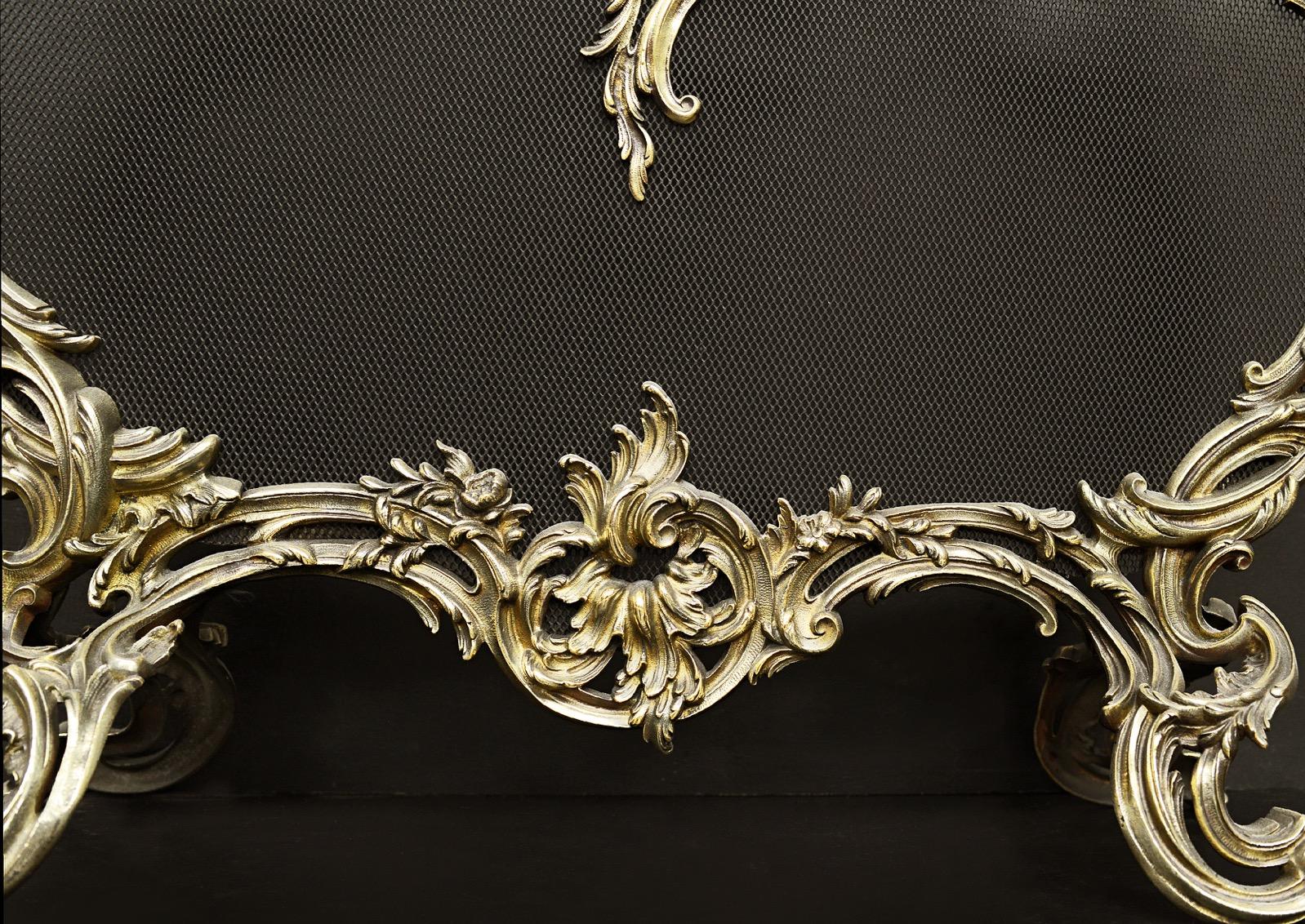 A French Louis XV style brass firescreen with scrolls and leaf form. The mesh embellished with cherub and leaf decoration. Fine quality. 19th century.

Height:	912 mm      	35 ⅞