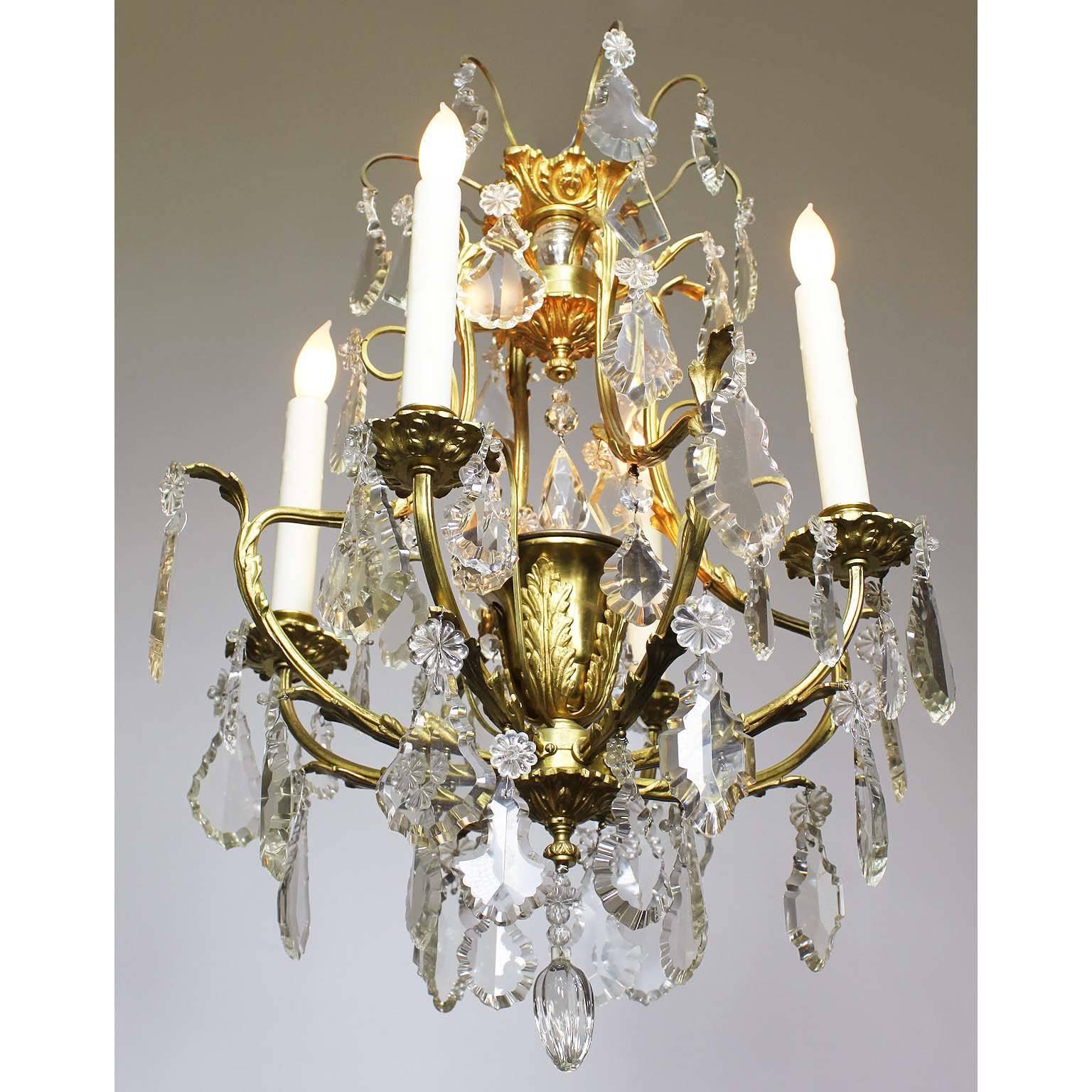 A charming French Louis XV style gilt bronze and cut-glass four-light chandelier. The cage gilt bronze frame surmounted with cut-glass pendants, four candle-arms and a central cup-light, Paris, circa 1900-1920.

Measures: Height 22 1/2 inches