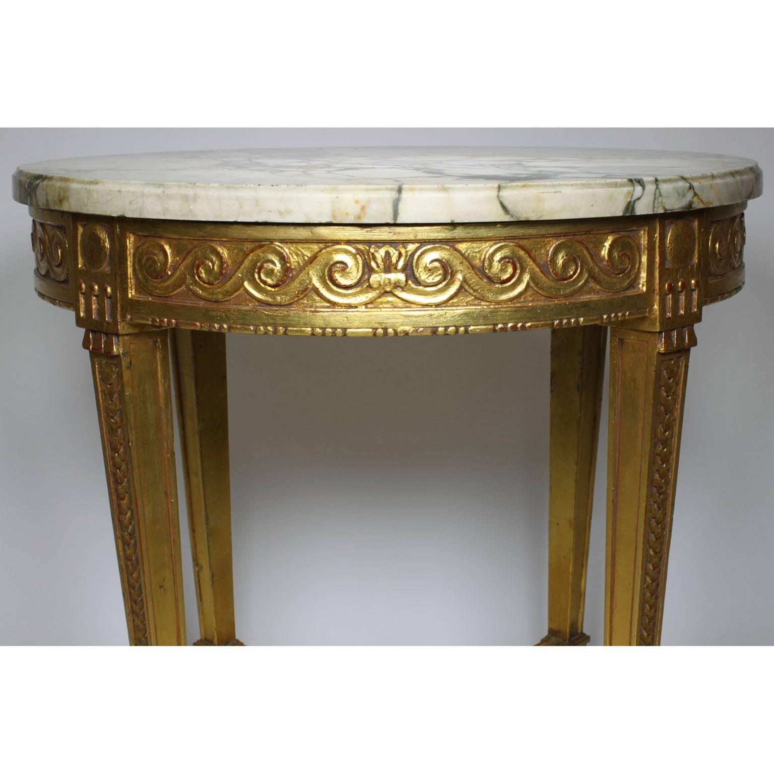 Ein französischer Guéridon-Tisch im Stil Louis XV aus geschnitztem Goldholz mit Marmorplatte. Runder Rahmen aus vergoldetem Holz, geschnitzt, mit vier geschwungenen Kabriolettbeinen, die mit einer Bahre mit kreisförmigem Mittelpunkt verbunden sind,