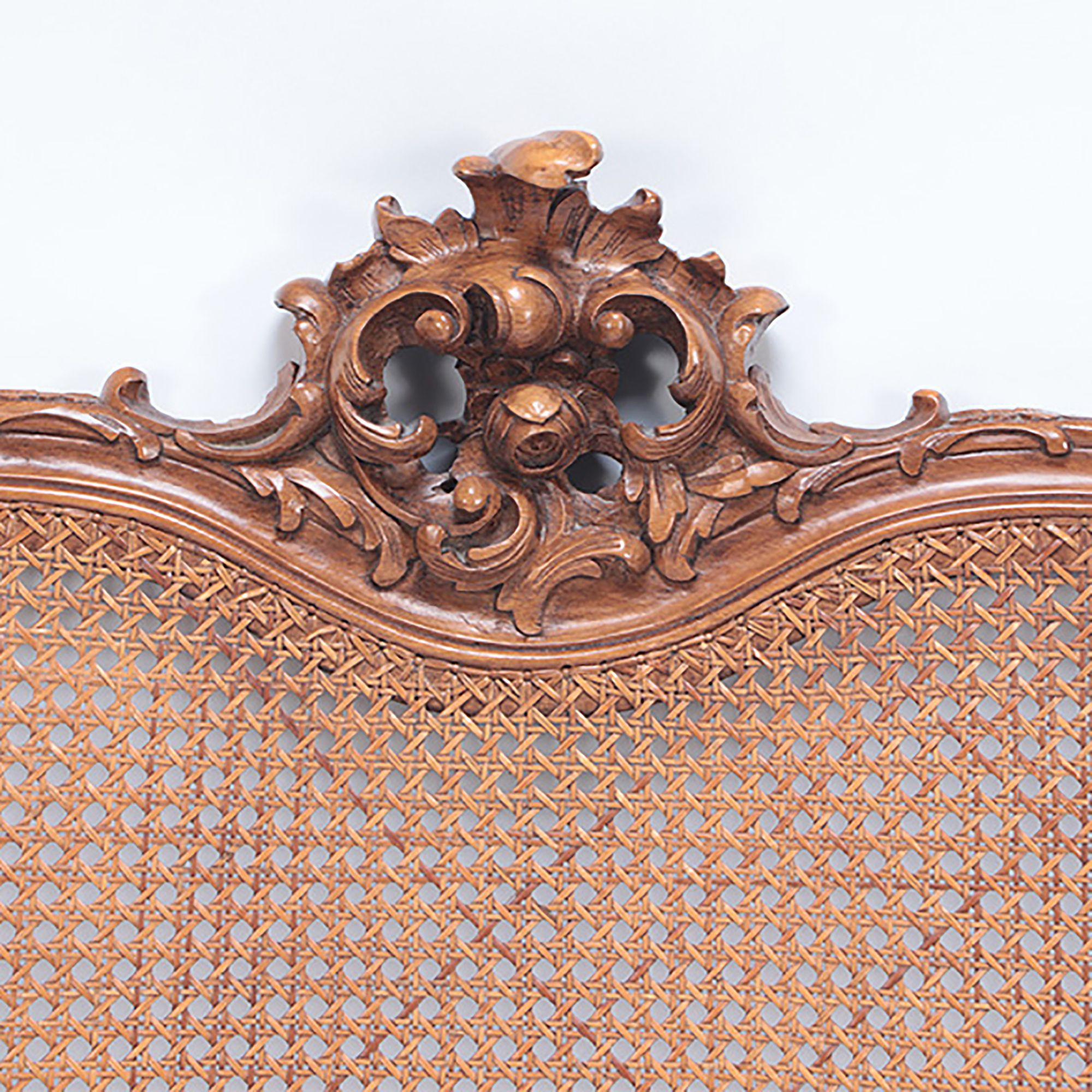 A French Louis XV style king size cain head board with carved crest. circa 1940.