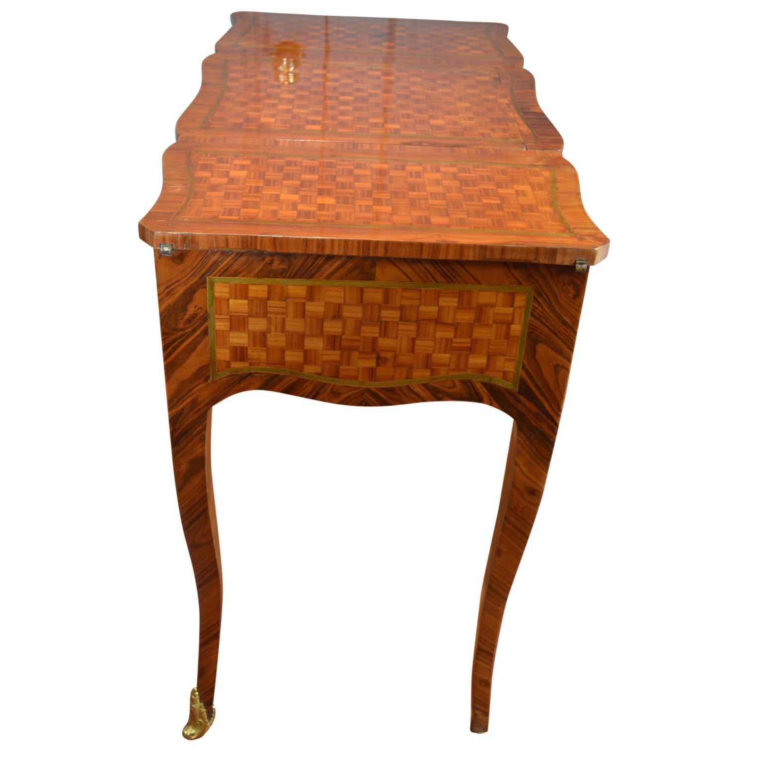 A beautifully inlaid marquetry coiffeuse in the pure Louis XV style; the carcass inlaid in tulipwood, kingwood and amaranth woods resting on cabriole legs; the top central section lifts back and slides to reveal a work surface and make-up mirror;