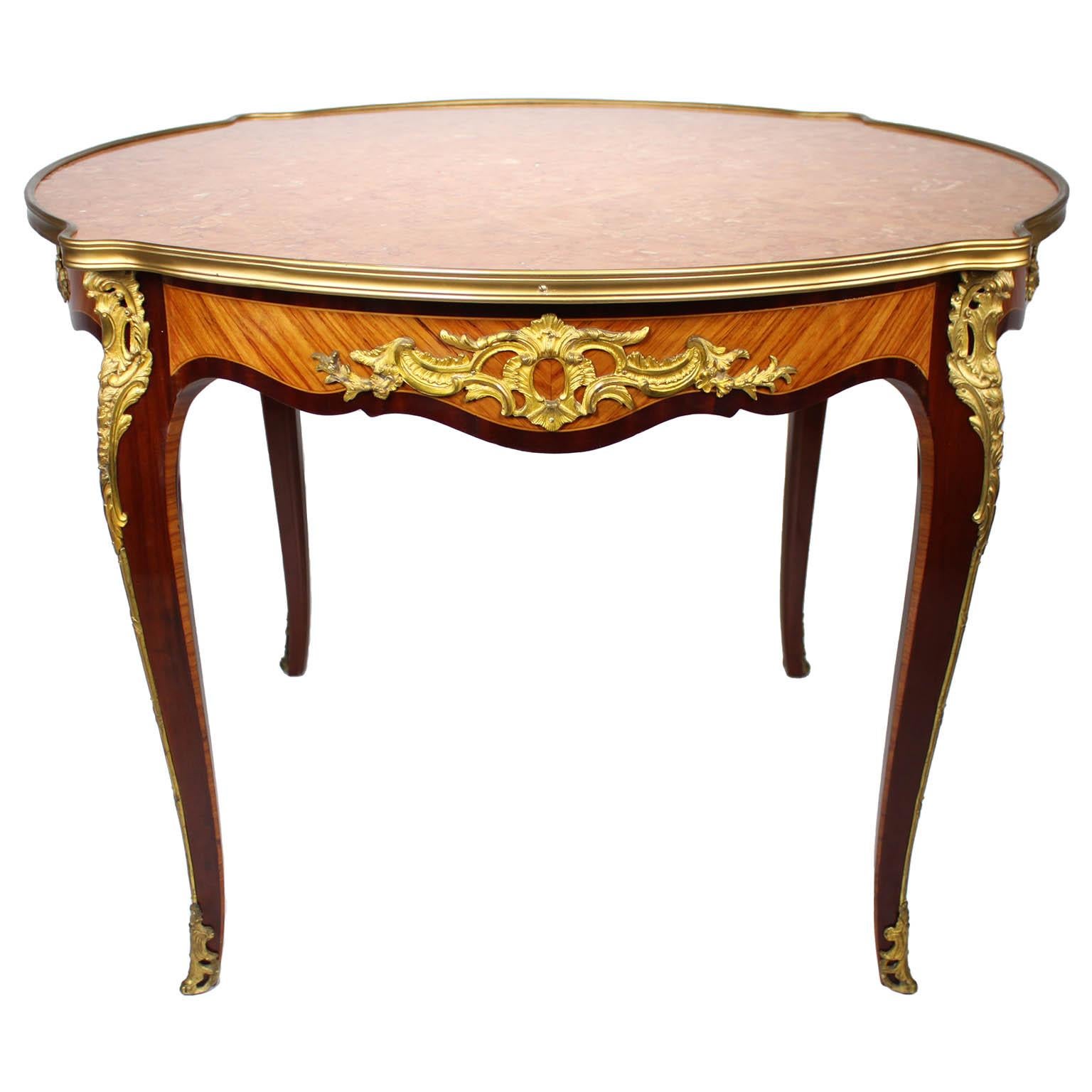 A Very Fine French 19th-20th Century Louis XV Style Mahogany and Tulipwood Gilt-Bronze Mounted Circular Side or Center Table (Gueridon) Probably by Maison Jansen, Paris. The four cabriolet legs fitted on each angle with acanthus ormolu mounts, the