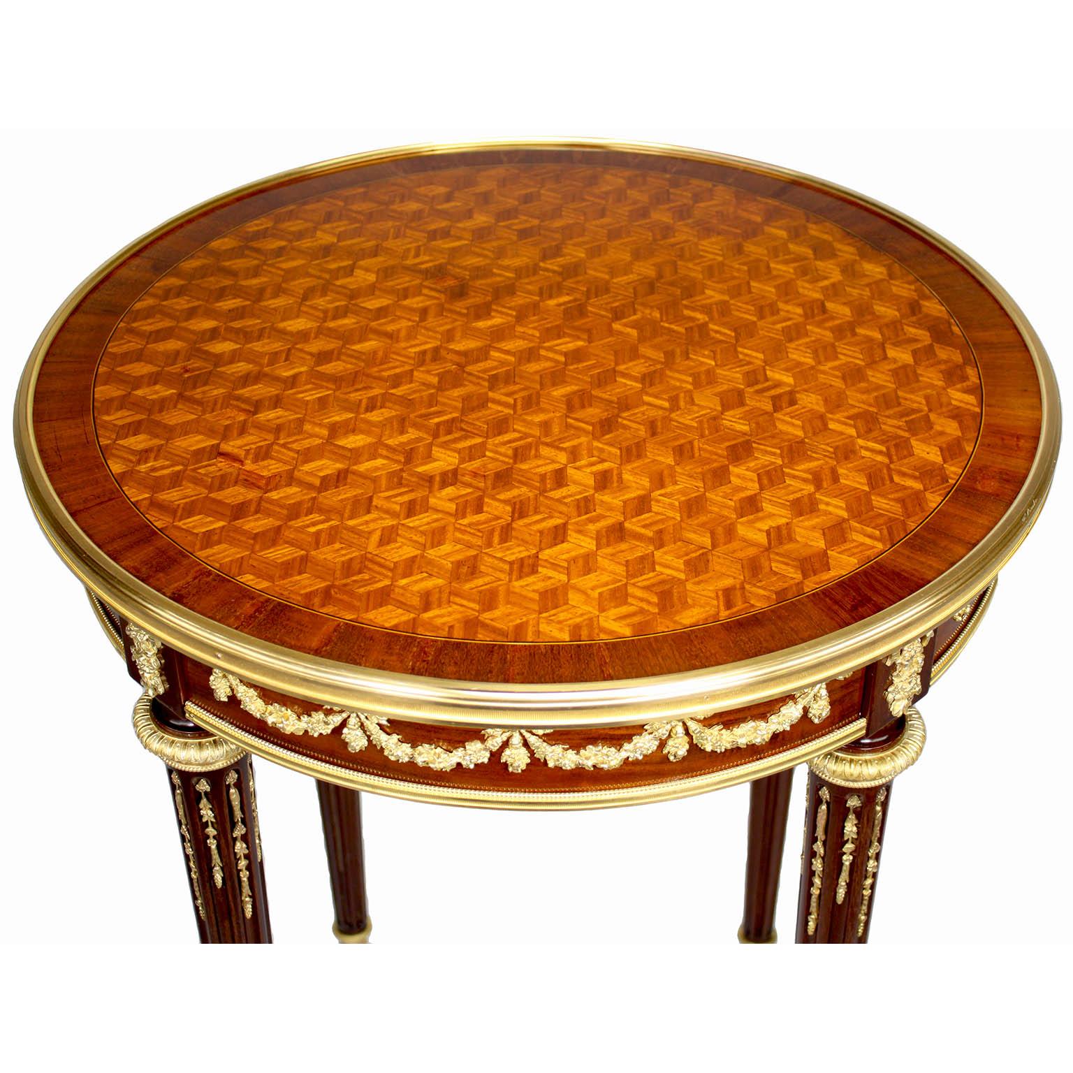 A Fine French 19th-20th Century Louis XVI Style Mahogany, Tulipwood and Gilt-Bronze (Ormolu) Mounted Belle Époque Guéridon Circular Side-Table with a Parquetry Top, by François Linke (1855-1946). The single-drawer end table inset with a symmetrical