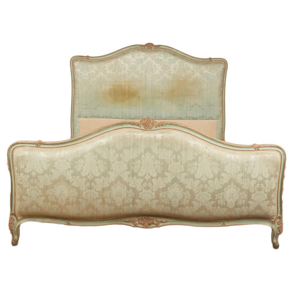 A French Louis XV style painted full size bed with upholstered headboard and footboard. The frame having beautiful carvings and painted with a robin's egg blue color circa 1930.
Foot board: 32