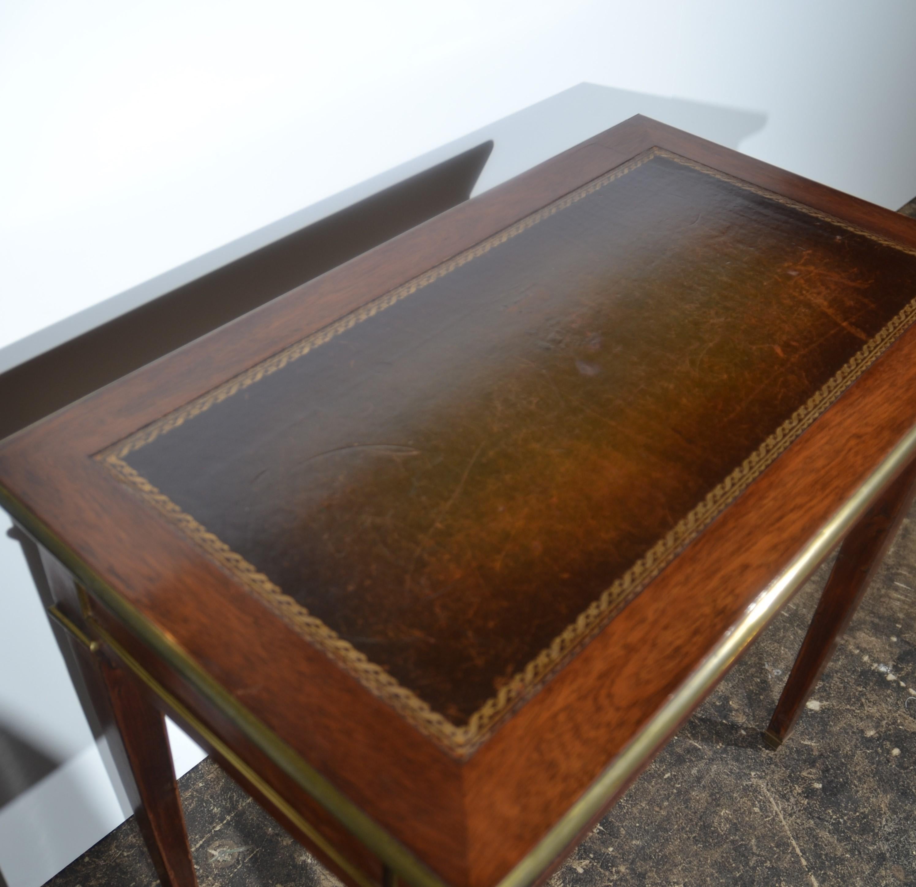 A French mahogany Louis XVI neoclassical desk / table with single oak lined drawer. Brass edging trim throughout. Leather writing surface with gold tooling. c.1880.