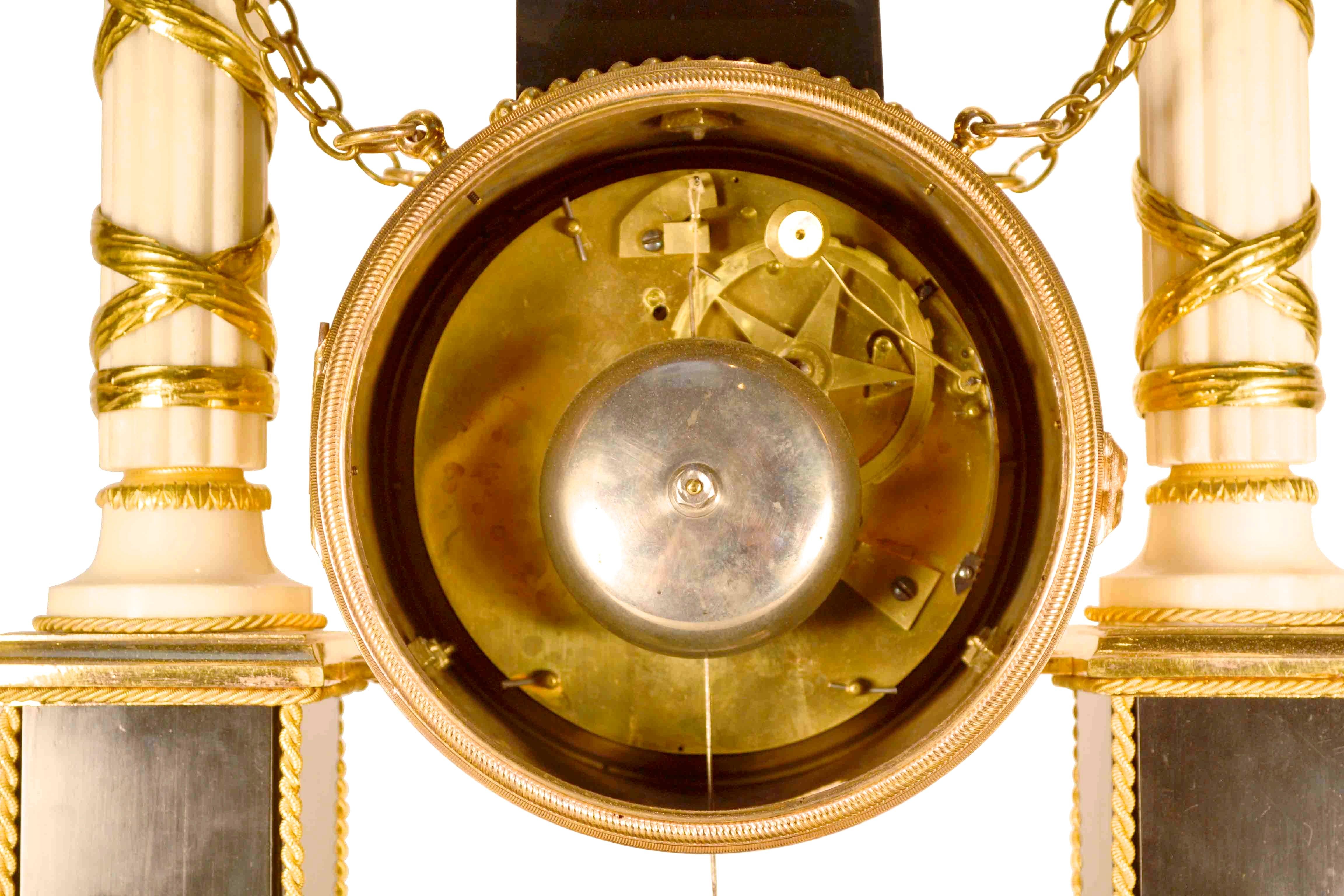 Pendule de cheminée d'époque Louis XVI en marbre noir et blanc Ormolu, réalisée dans le dernier quart du XVIIIe siècle. Le cadran en émail blanc avec chiffres arabes noirs est contenu dans un boîtier en forme de tambour surmonté d'une figure