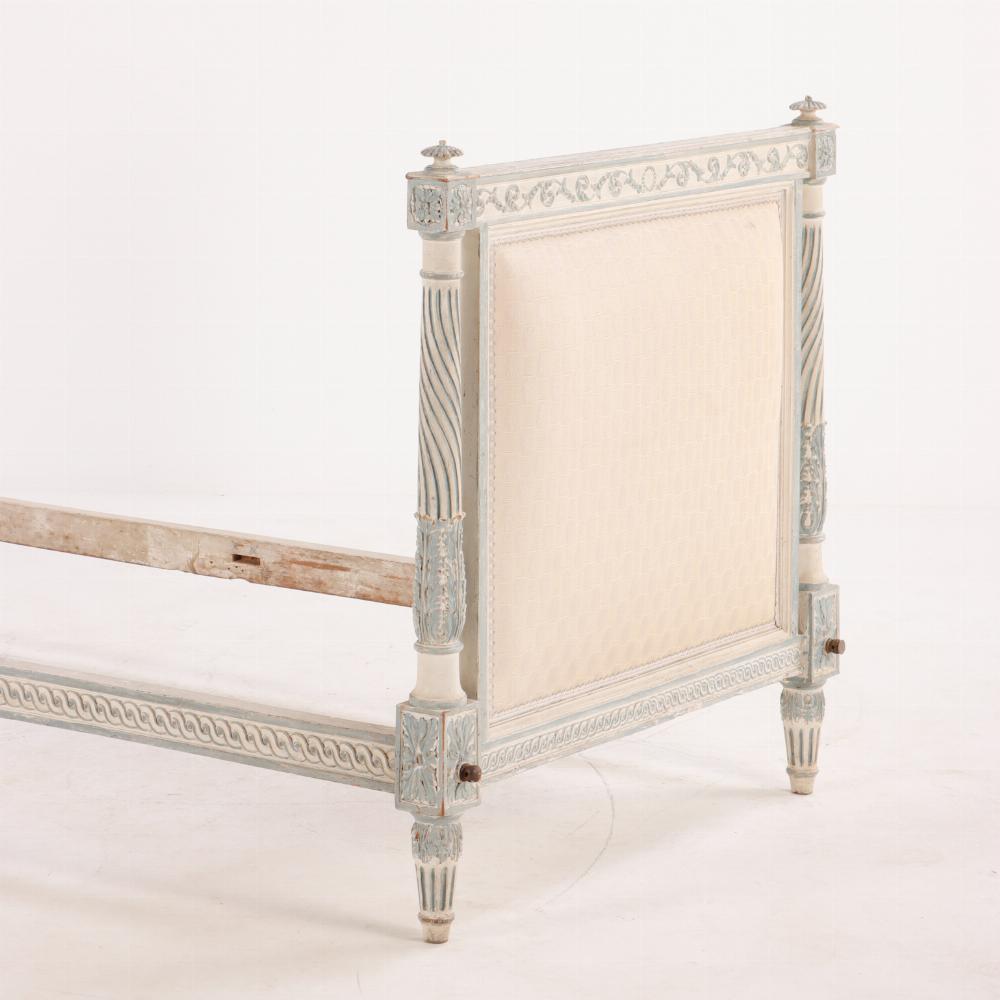 French Louis XVI painted and carved daybed, 18th C. Beautifully carved with with spiral fluted columns supporting upholstered head and footboards, topped by rosette finials, and overall foliate embellishments. Retains old white painted surface with