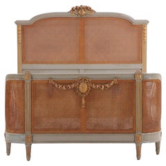Antique A French Louis XVI style carved, painted and giltwood full size bed, C 1900.