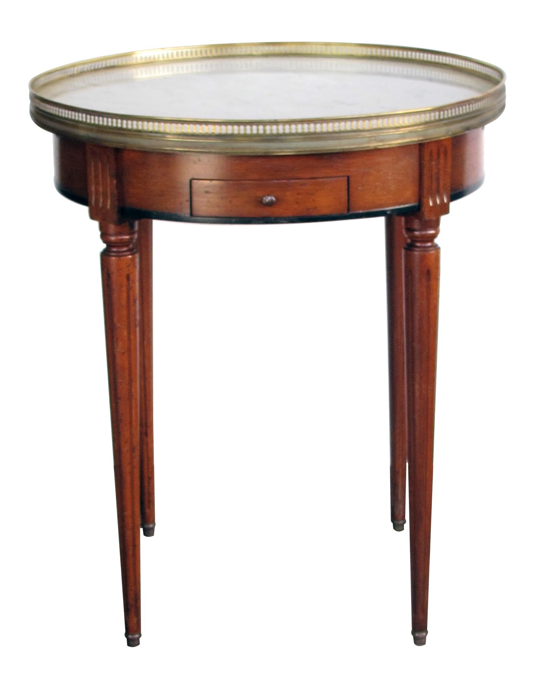 A tailored French Louis XVI style fruitwood circular side/bouillotte table with Carrara marble top; perfect for a side table or between two chairs, the round Carrara marble top within a pierced brass gallery; the apron fitted with two small drawers