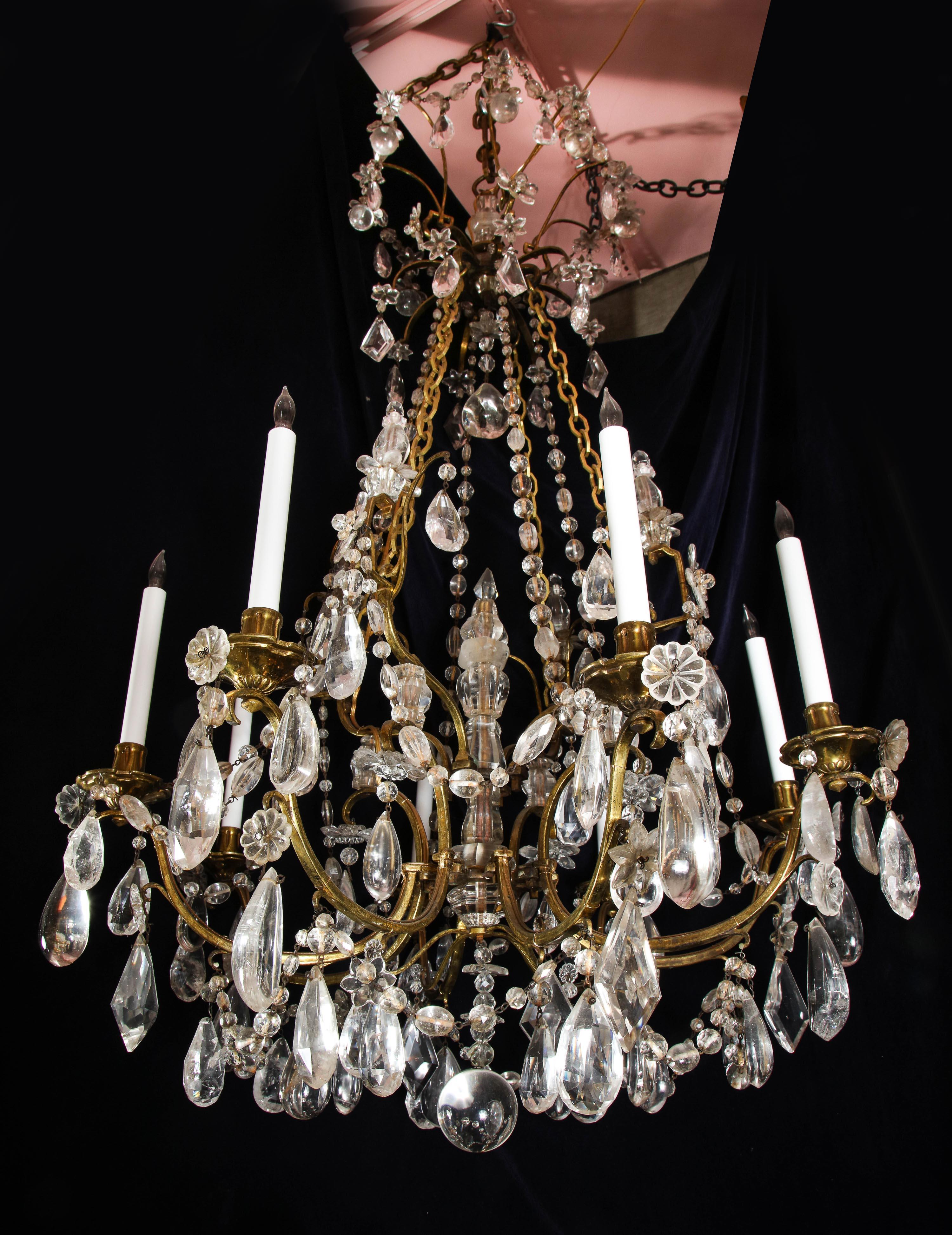A large French Louis XVI gilt bronze and cut rock crystal multi light chandelier of superb quality embellished with cut rock crystal prisms, flowers, vases, chains and further adorned with a central cut rock crystal obelisk.