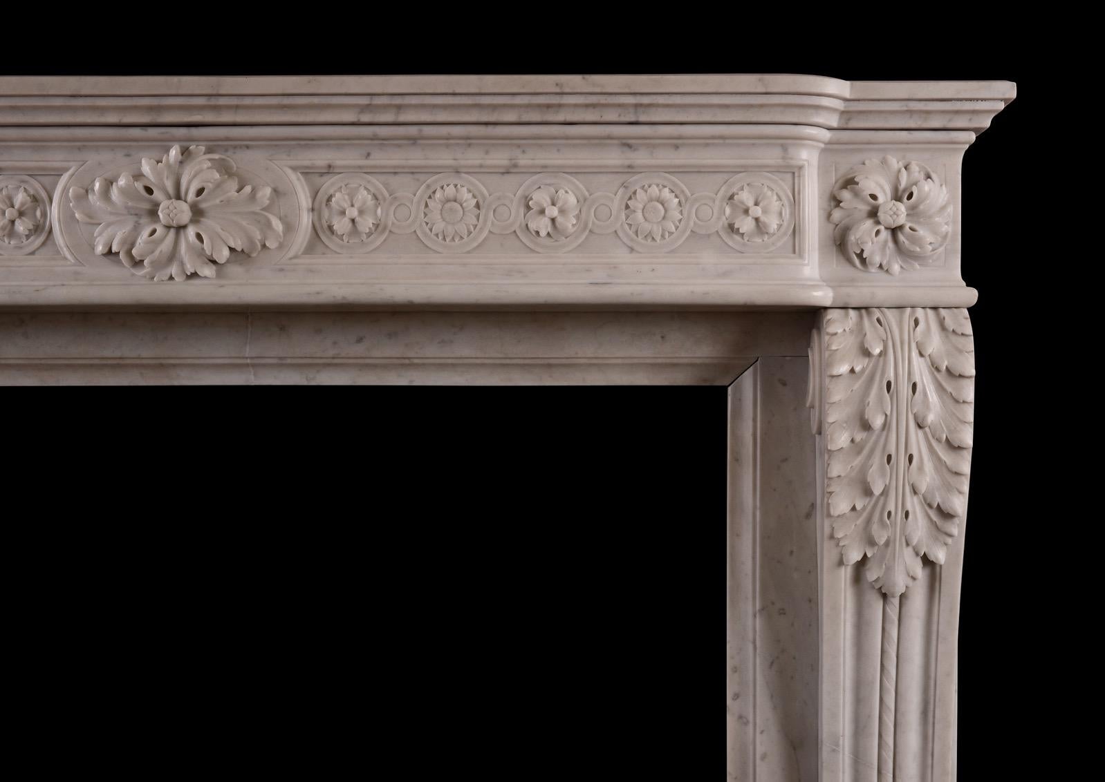 An unusually high mid 19th century French Louis XVI style fireplace in Carrara marble. The delicately carved shaped frieze with floral guilloche pattern, oval patera to centre and swirling end blockings. The jambs with carved scroll to base and