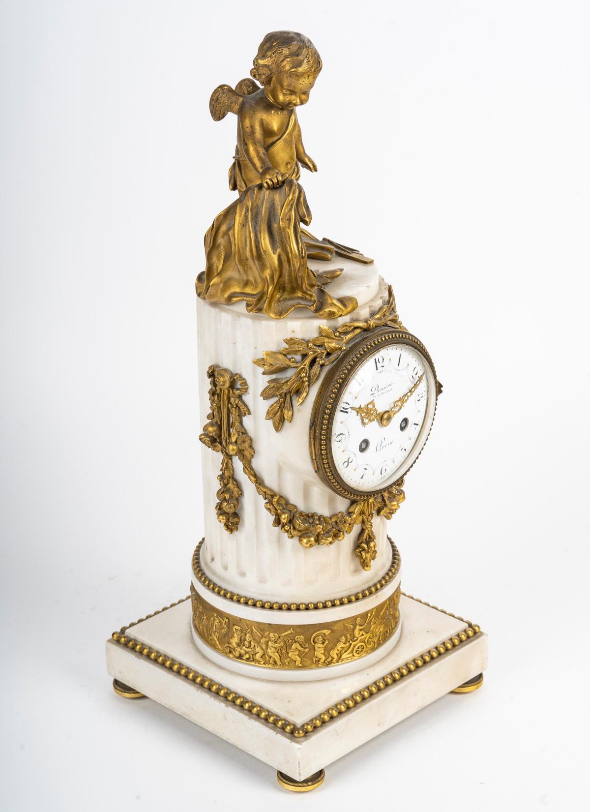 Pendule de style Louis XVI en marbre blanc monté sur bronze doré 
En forme de colonne cannelée, le cadran circulaire en émail avec des chapitres arabes et des aiguilles en métal doré en forme de lyre percée et de fleur de lys, dans une lunette à