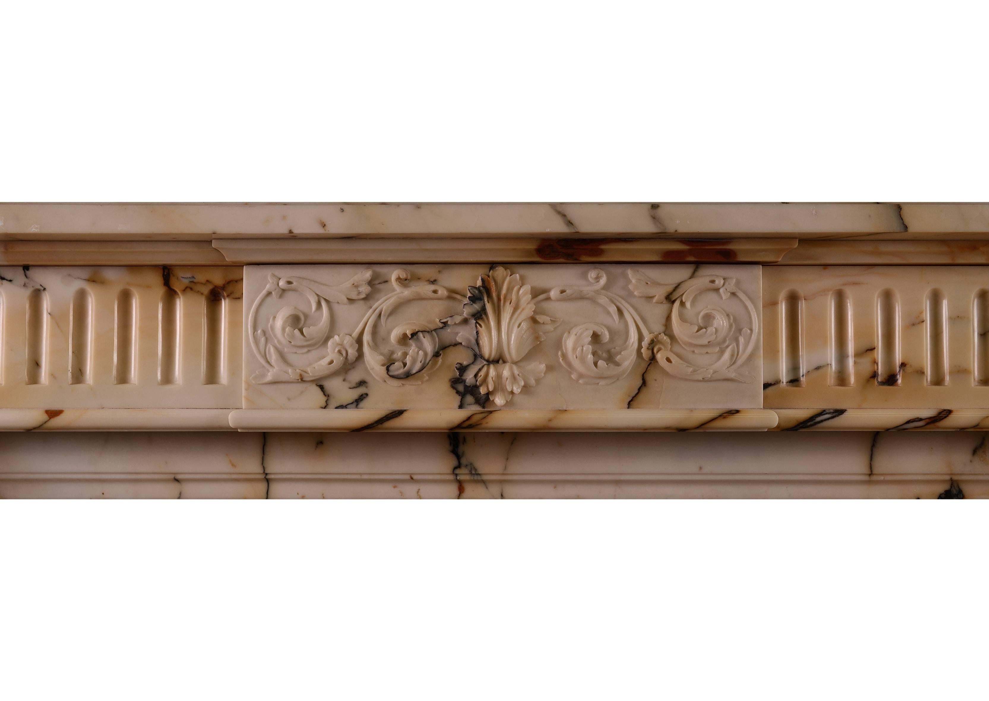 A good quality Louis XVI style antique fireplace in Italian Pavonazzo marble. The stop fluted jambs surmounted by carved panels with flowers and tied ribbons. The frieze carved centre panel with scrolled foliage and cartouche to middle, flanked by