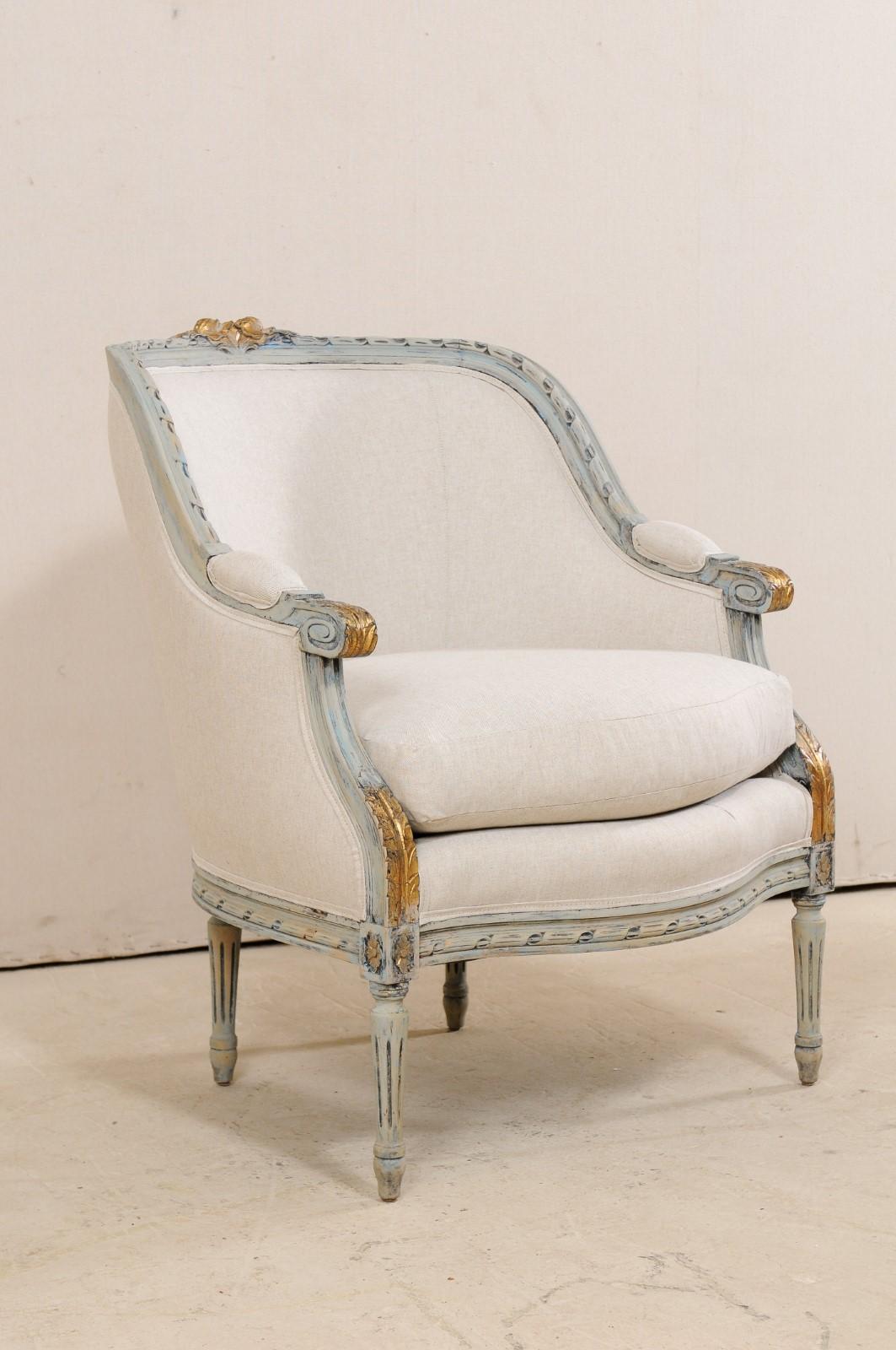 A French Louis XVI style occasional barrel-back bergère chair from the mid-20th century. This armchair from France is accentuated with rope carved trim about it's top rail and seat railing. The crest is adorn in a carved-wood bouquet, while acanthus