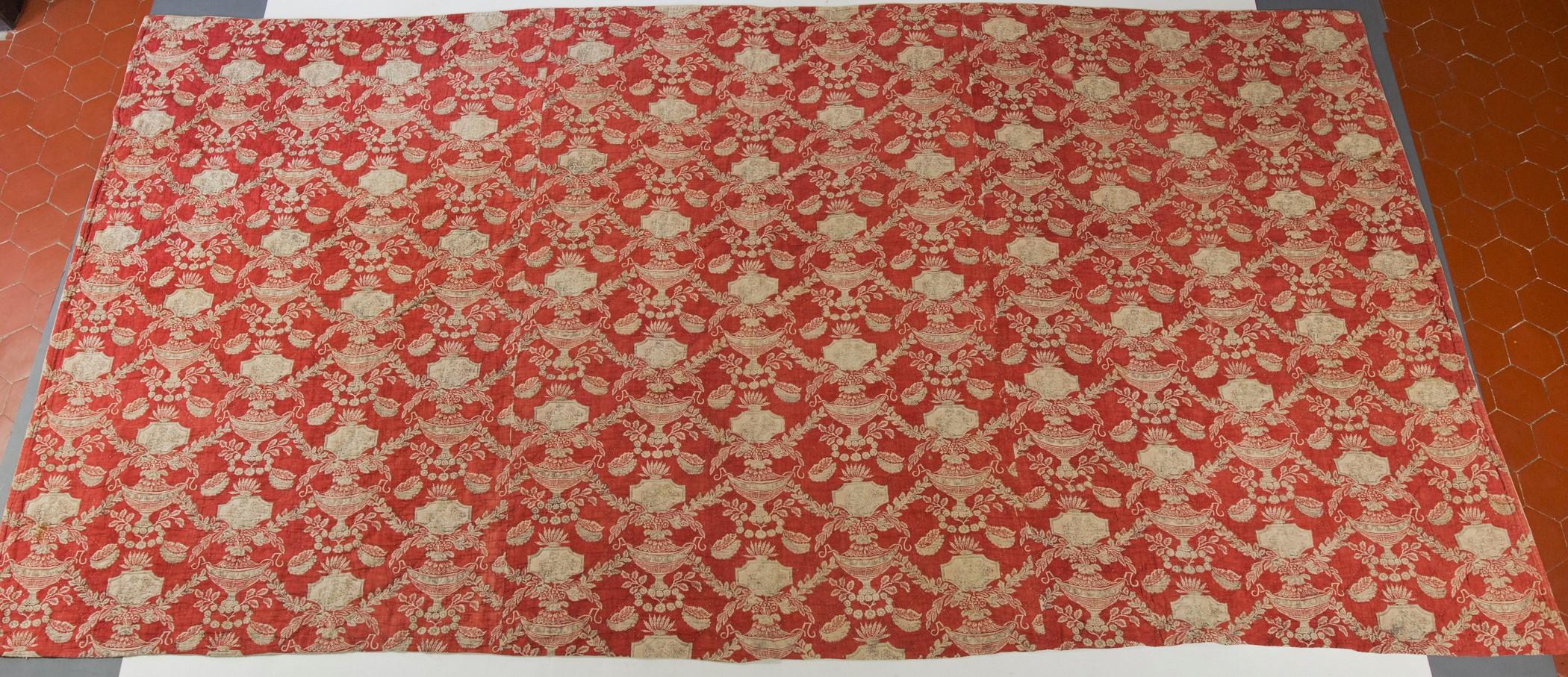 Circa 1785/1800
France

Beautiful quilt or part of bed in cotton printed on a wooden block on a background dyed in madder red from the end of the 18th century. Neoclassical decor arranged with large antique vases surmounted by medallions with scenes