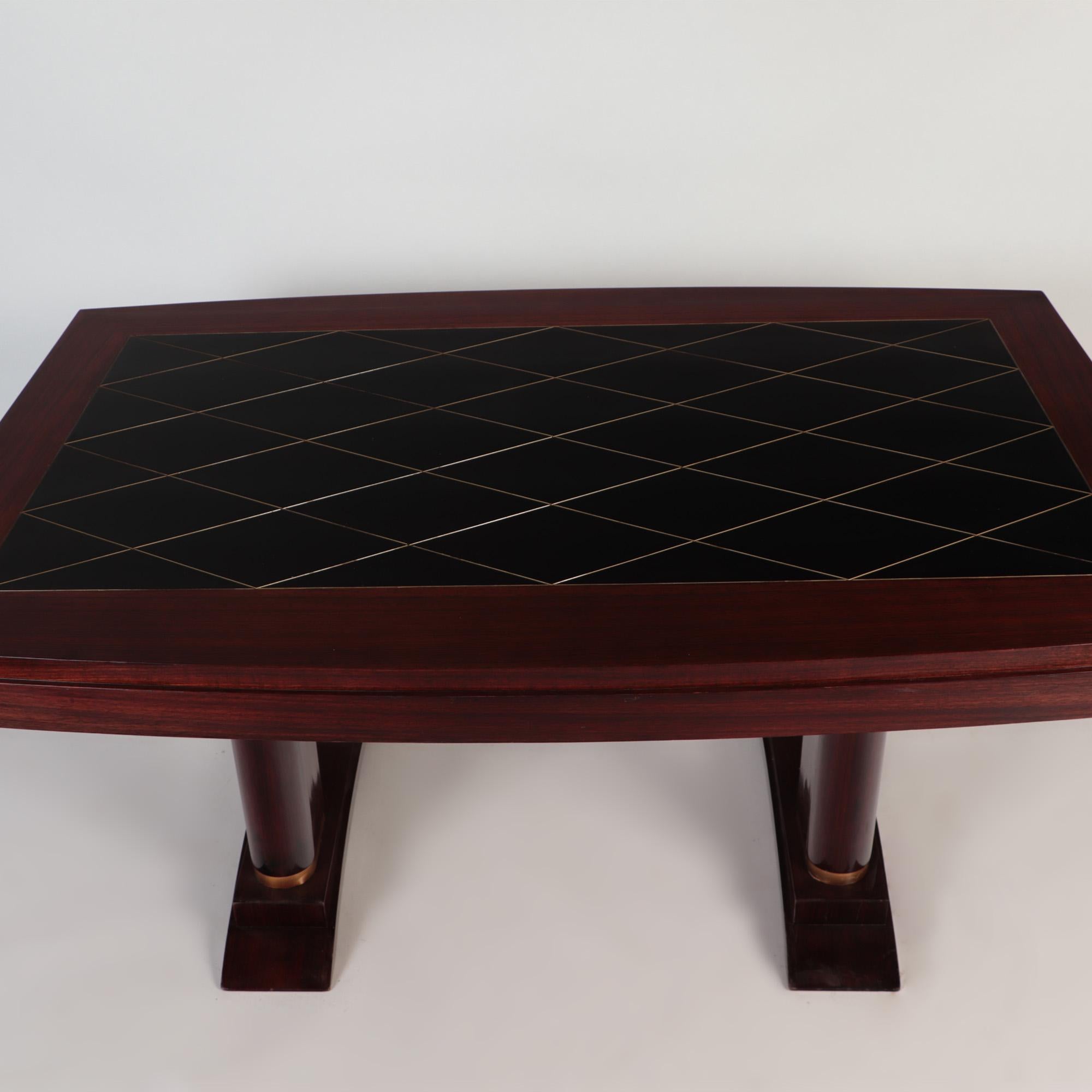 A French mahogany Art Deco dining table with brass details by Robert Desnos for Editions AV, one drawer on each side, circa 1930.