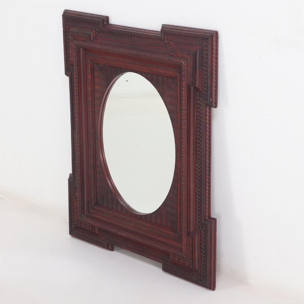 Lo specchio ovale è sostenuto da una cornice con intagli a increspature e volute. Un meraviglioso specchio di rappresentanza.