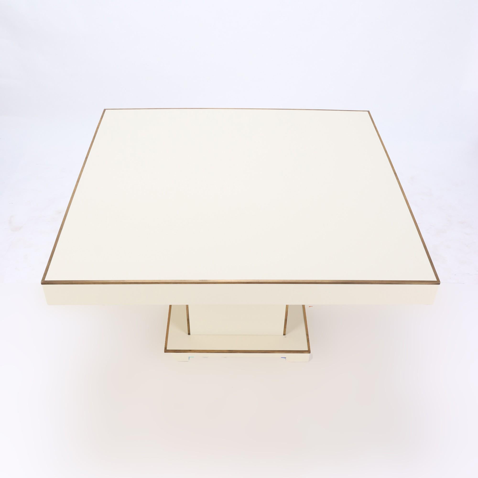 A French Maison Jansen lacquer pedestal table with brass trim details, circa 1970.