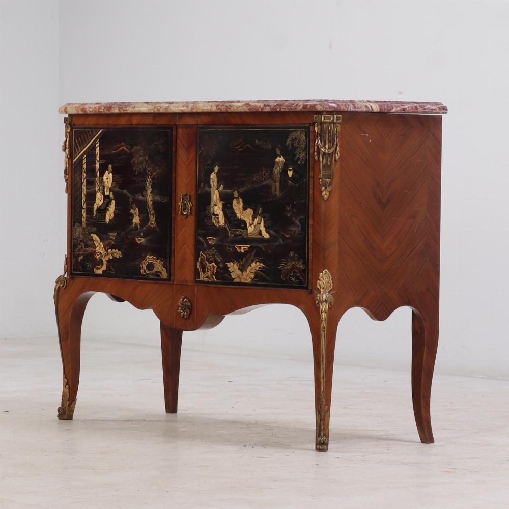 Il piano in marmo rettangolare sagomato sovrasta un'unica anta decorata con due pannelli in lacca cinese raffiguranti figure in giardini, sostenuti da gambe cabriole con scivoli in bronzo dorato sugli angoli e supporti ai piedi.

Conserva