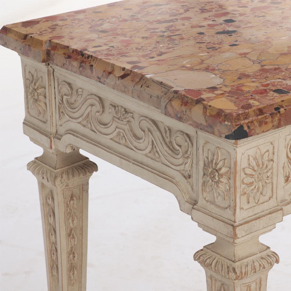 Questo tavolo antico proveniente dalla Francia ha un piano in marmo di forma rettangolare che sovrasta un grembiule magnificamente intagliato sostenuto da quattro gambe quadrate affusolate, con ulteriori elementi intagliati. 
