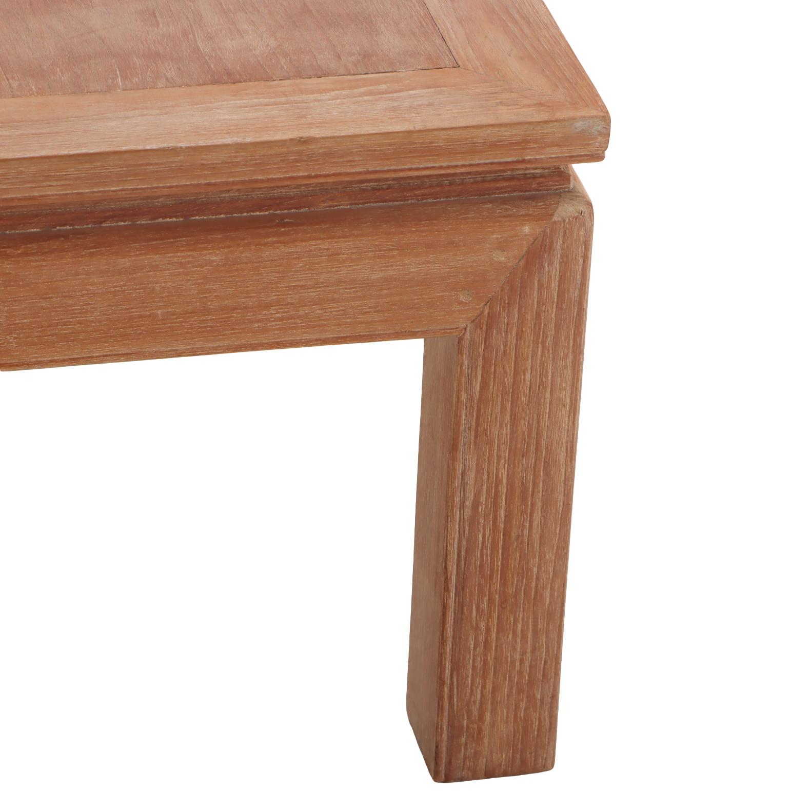 De forma sencilla y arquitectónica, esta mesa auxiliar cuadrada presenta un acabado de madera cerusa que resalta el veteado natural al tiempo que le confiere una pátina suave y texturizada. Las patas anchas y cuadradas y el borde superior saliente