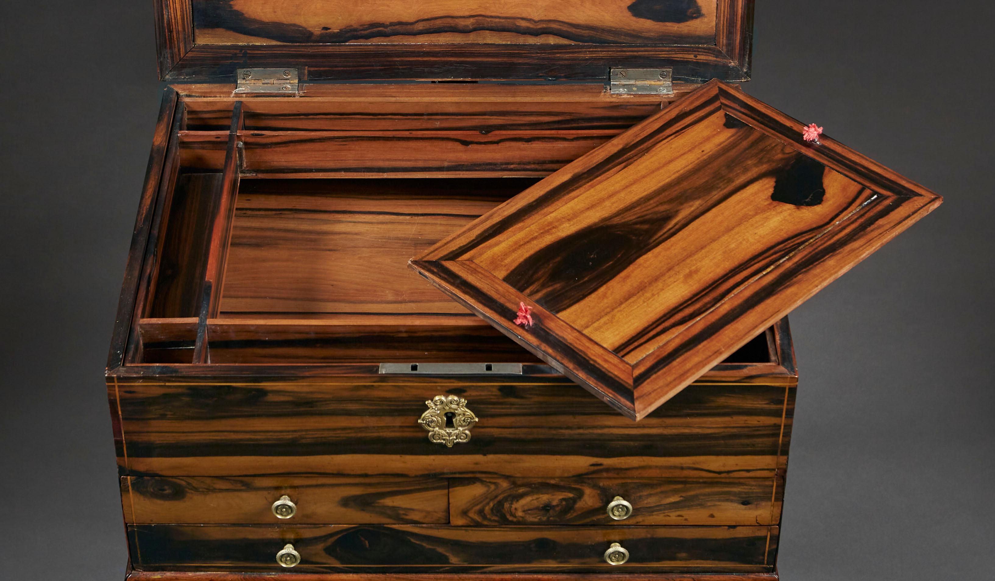 A fine mid nineteenth century coromandel bedside table, the lid opening to reveal the compartmental interior, with four small drawers to the frieze, all supported on turned and fluted baluster legs terminating in brass castors.