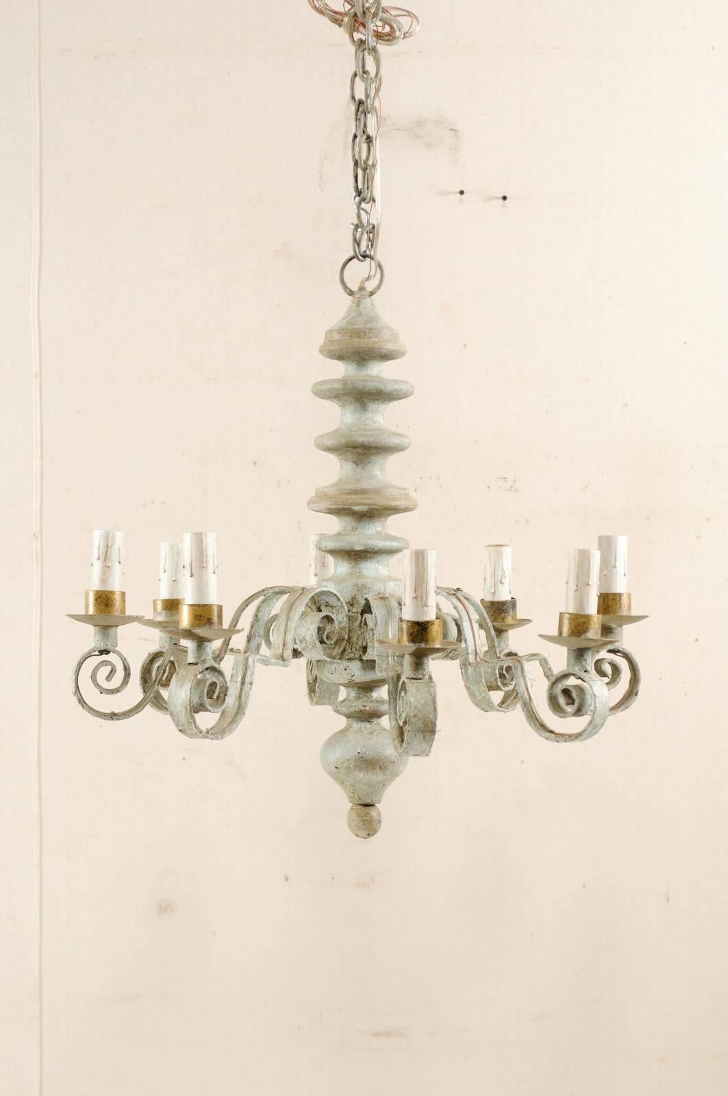 A lovely French vintage chandelier with turned central column. This French chandelier from the mid-20th century, features a beautifully turned central column with ball finial at it's bottom. There are eight scrolled iron arms emerging from the