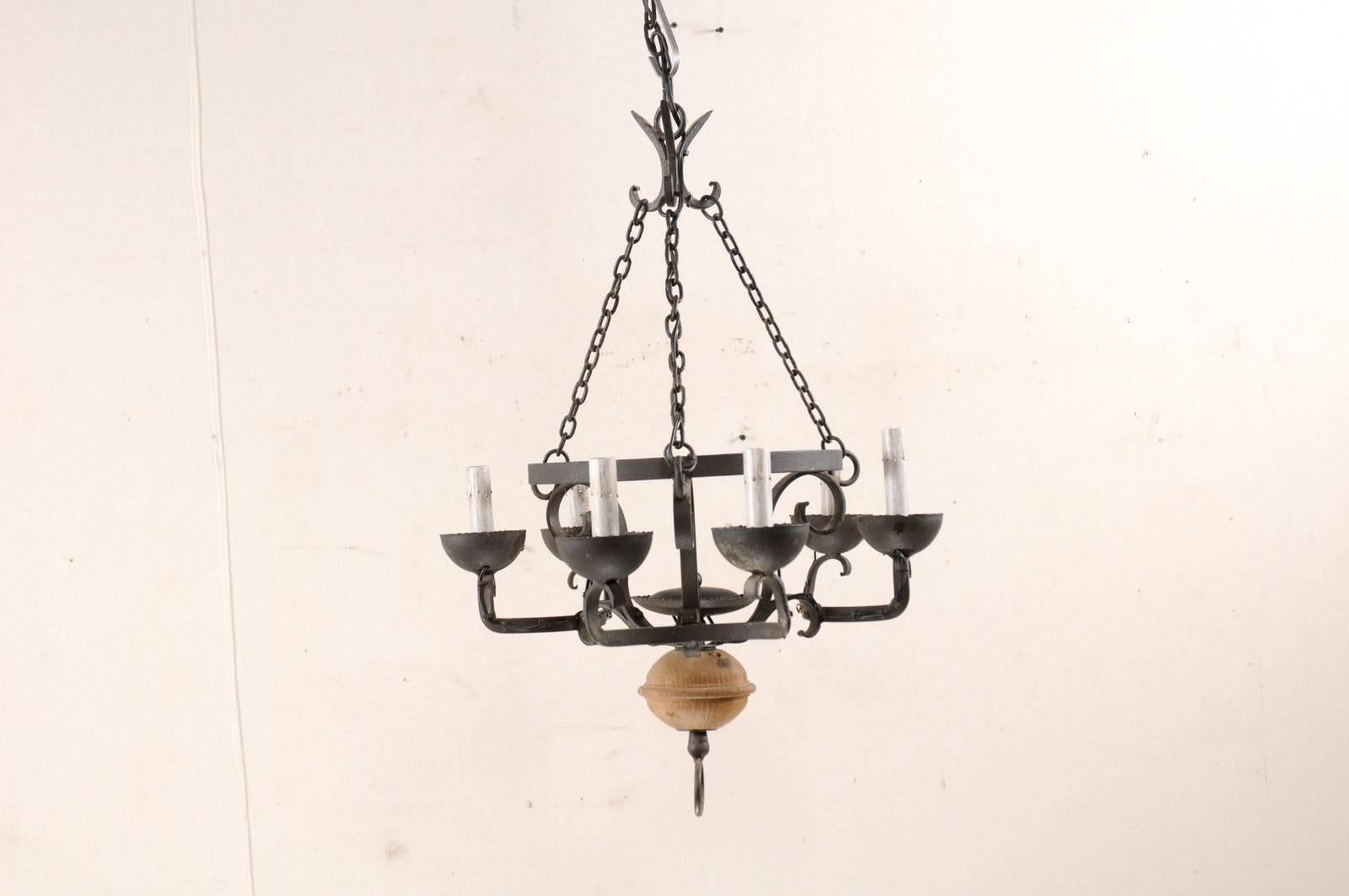 A French forged-iron chandelier with wood ball accent from the mid-20th century. This French vintage chandelier features a black iron basket-shaped center, nicely contrasted with a natural wooden orb at it's lower base, and iron o-ring finial at the