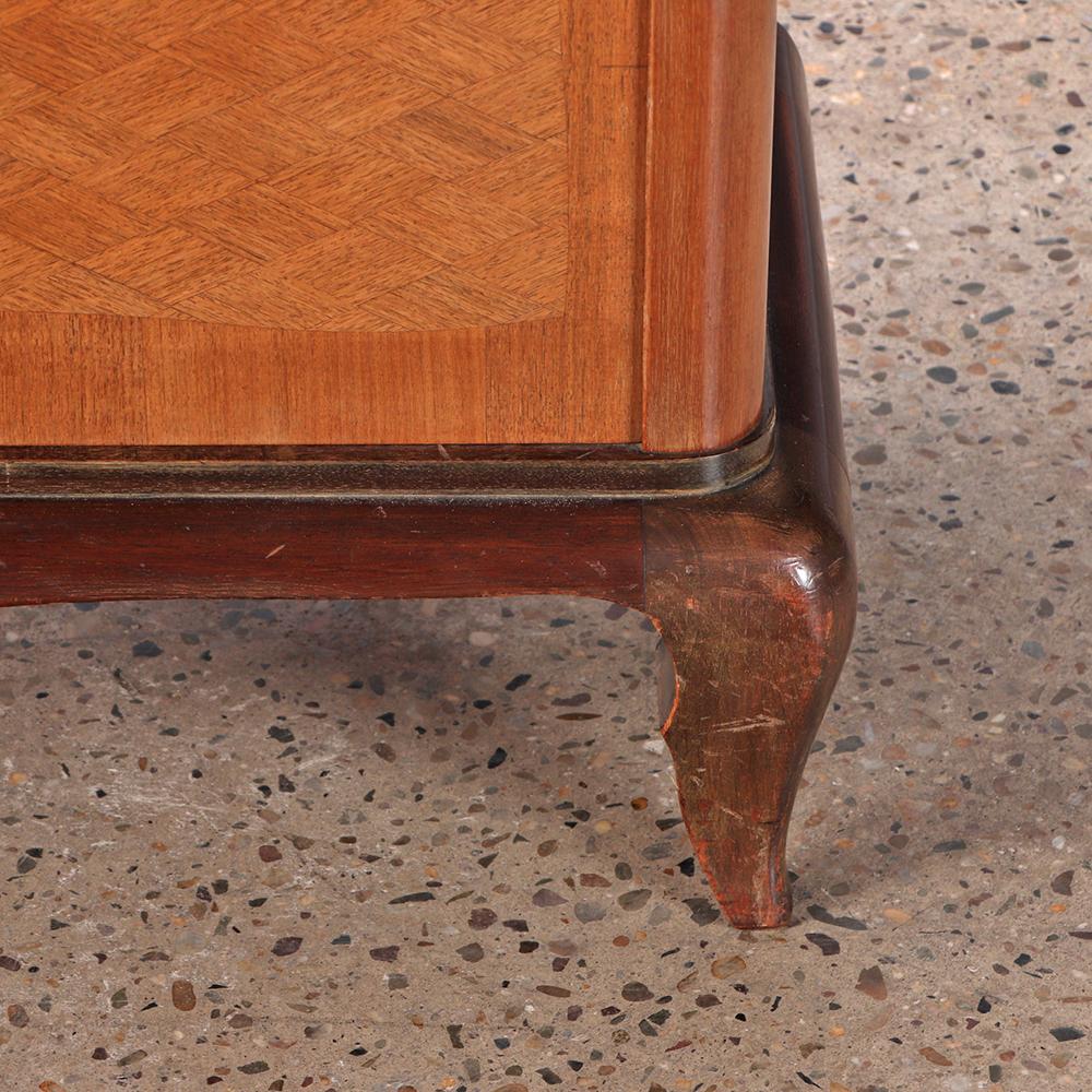 A refined French bar cabinet exhibiting the elegant modernist style associated with Jules Leleu later designs. The upper section fitted with mirrored interior and sliding glass doors, above a lower case with two doors finely inlaid in geometric