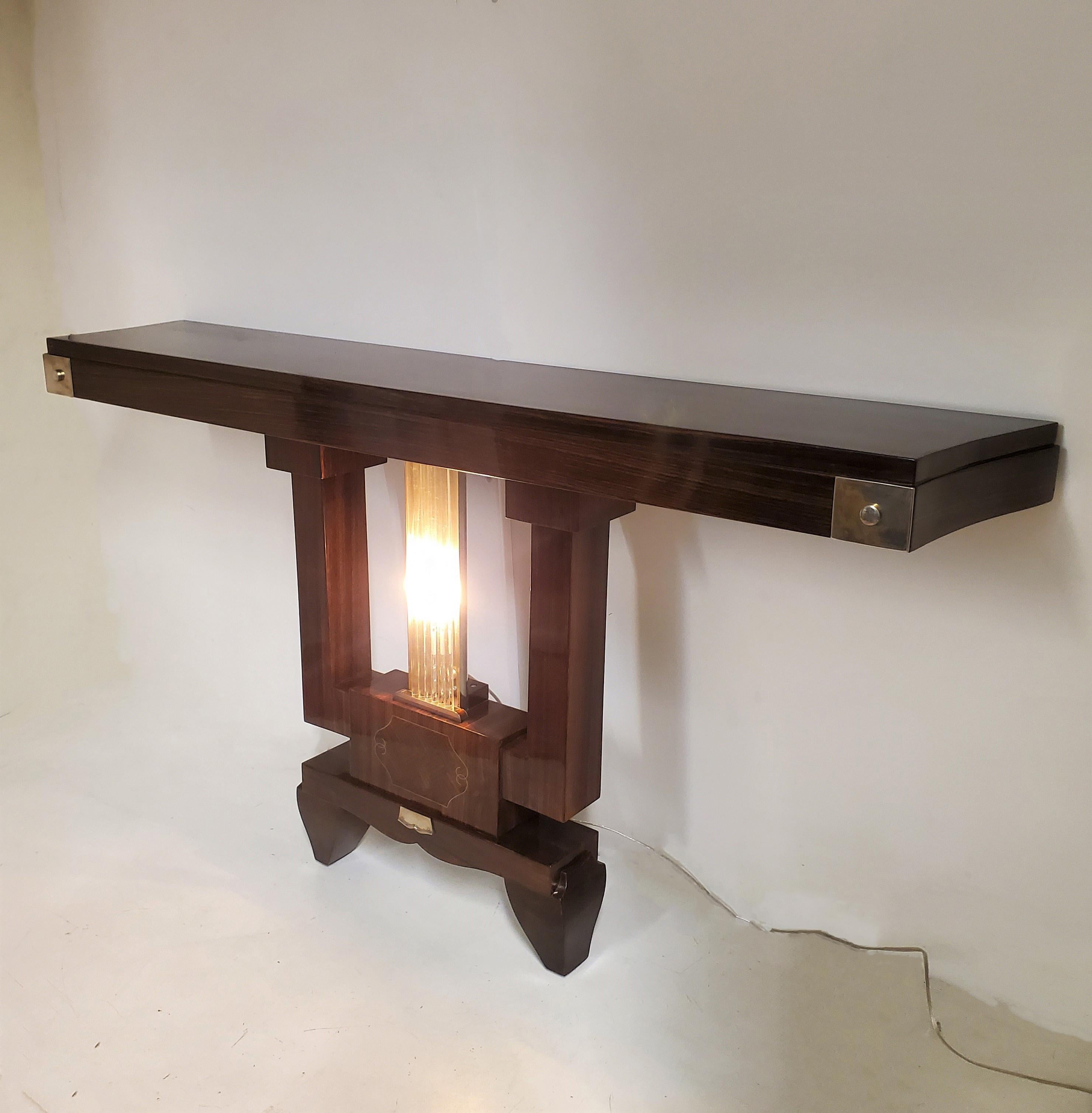Price listed is per single console. A pair is available.
Exquisite French Art Deco highly architectural console table in palisander, characterized by its open cube structure and a striking central focus of illuminated glass rods. 
The rectangular