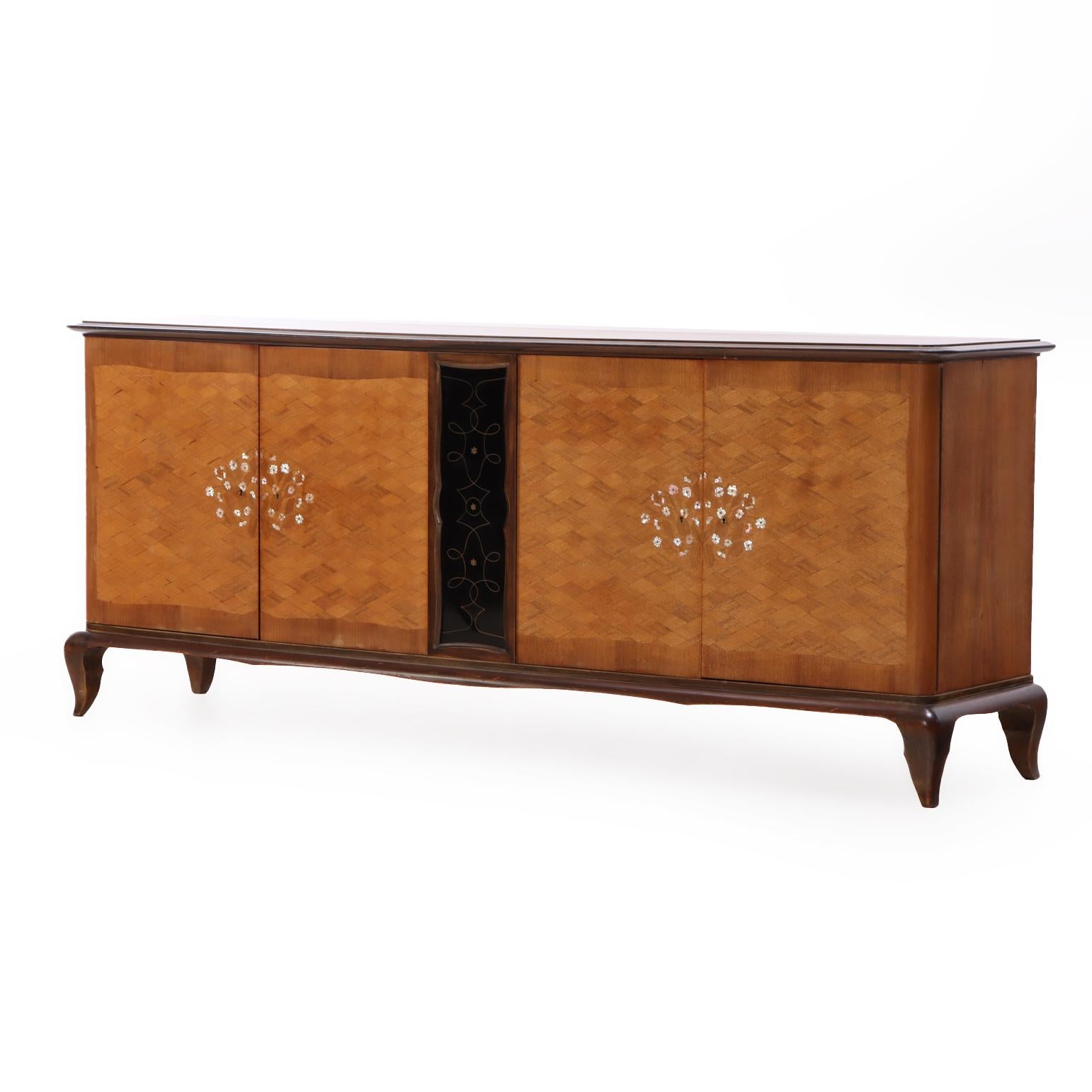 A refined French sideboard designed in the elegant modernist tradition attributed to Jules Leleu. The rectangular top above a case fitted with two pairs of doors, each finely decorated with geometric marquetry centered by delicate mother-of-pearl