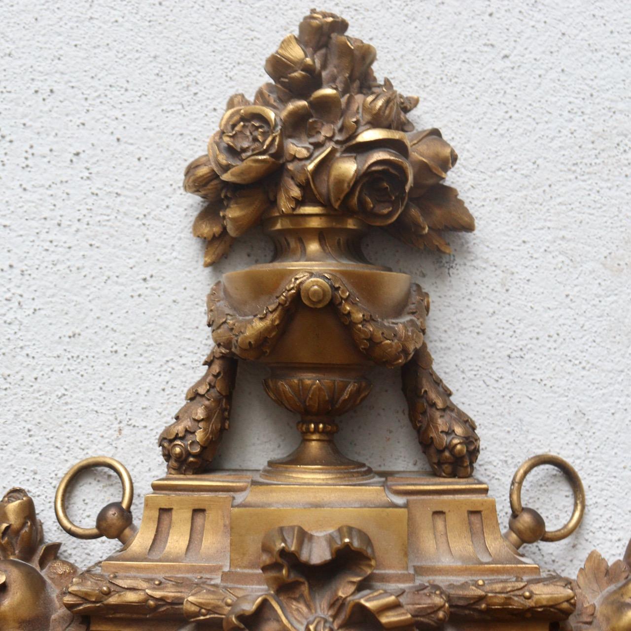 Ein französisches Füllhorn aus vergoldeter Bronze des 19. Jahrhunderts, von Susse Frères Paris

Ein Ormolu-Kartell in Form eines Wappenschildes, mit rundem weißem Email-Zifferblatt, signiert Susse Frères/A Paris, arabische Ziffern für die Stunden