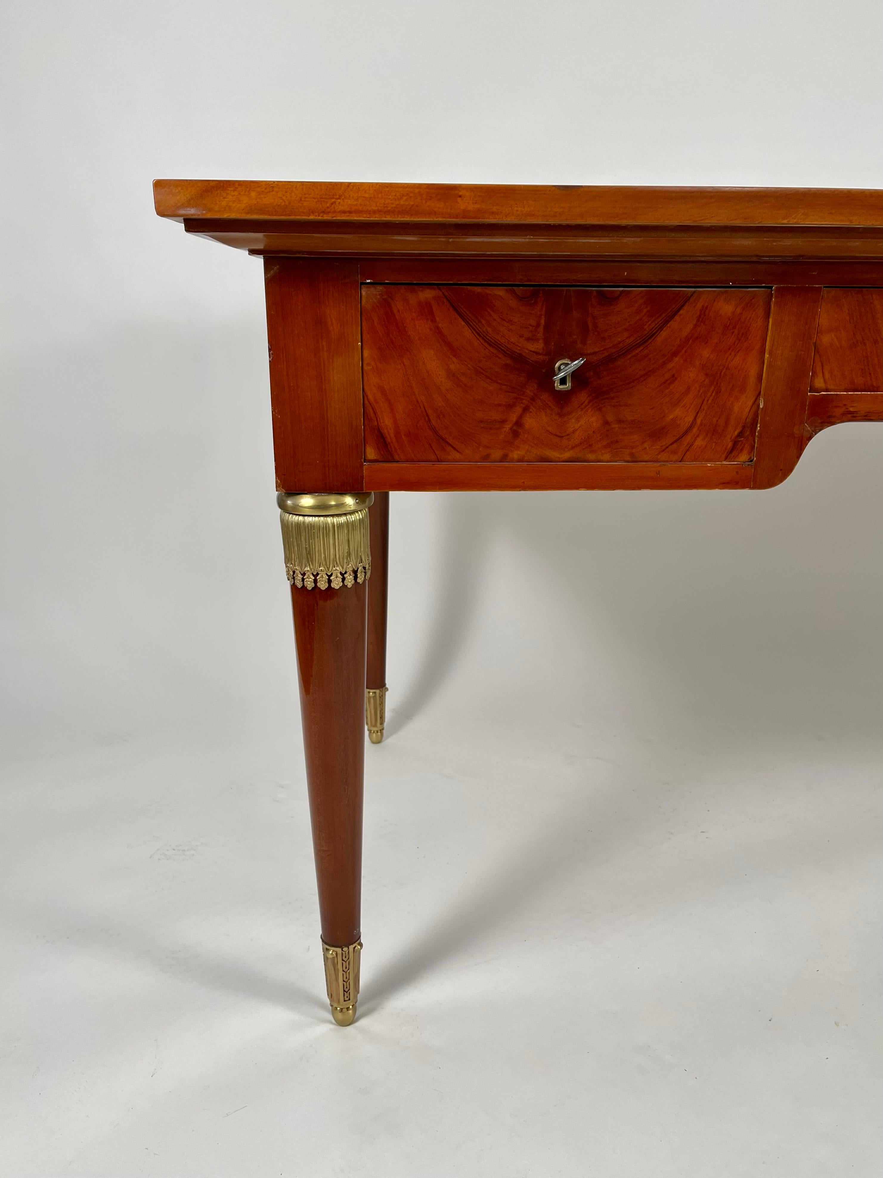 A fine quality French Empire style neoclassical desk, in richly figured mahogany with a gilt tooled leather top, over three frieze drawers supported by tapering cylindrical legs with gilt bronze mounts.
Provenance: A private collection, Boston.