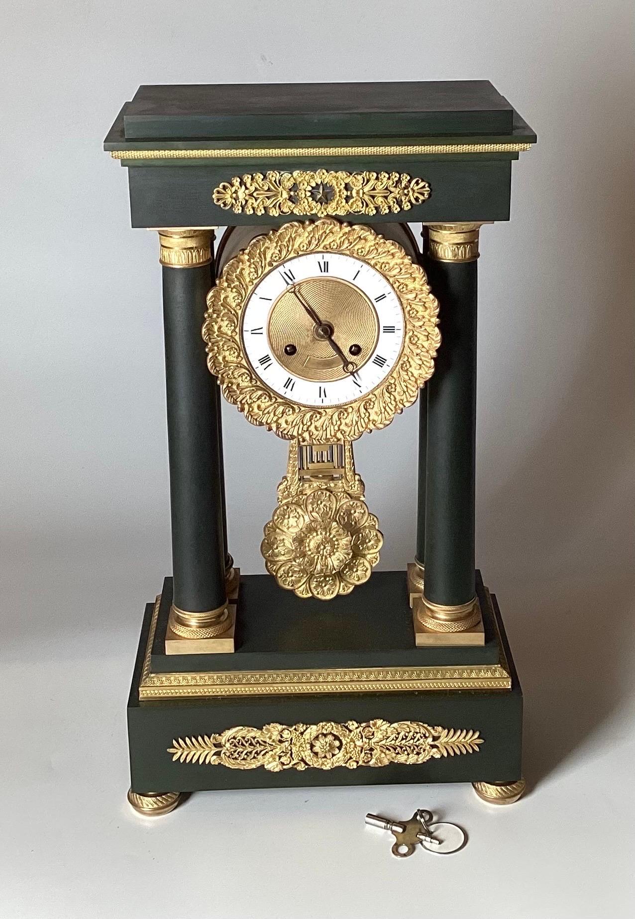 A French Neoclassical Style Gilt and Patinated Bronze Portico Clock, Retailed by J. E. Caldwell & Co., Philadelphia, 19th Century. The circular enamel dial having Roman numerals and inscribed 'J. E. Caldwell & Co.', the twin train movement with