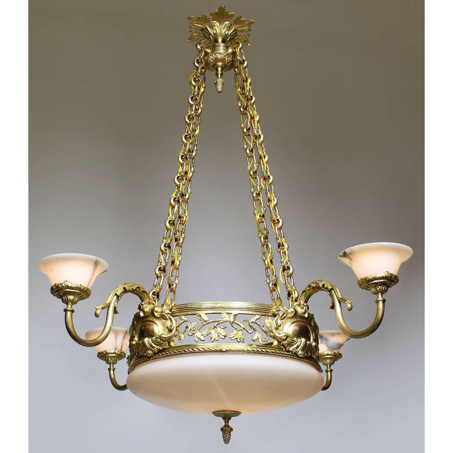 A fine French early 20th century neoclassical Revival style gilt-bronze, alabaster and opaline glass four-light chandelier. The intricate circular gilt-bronze frame suspended by four ornate gilt-bronze chain strands, the pierced apron decorated with
