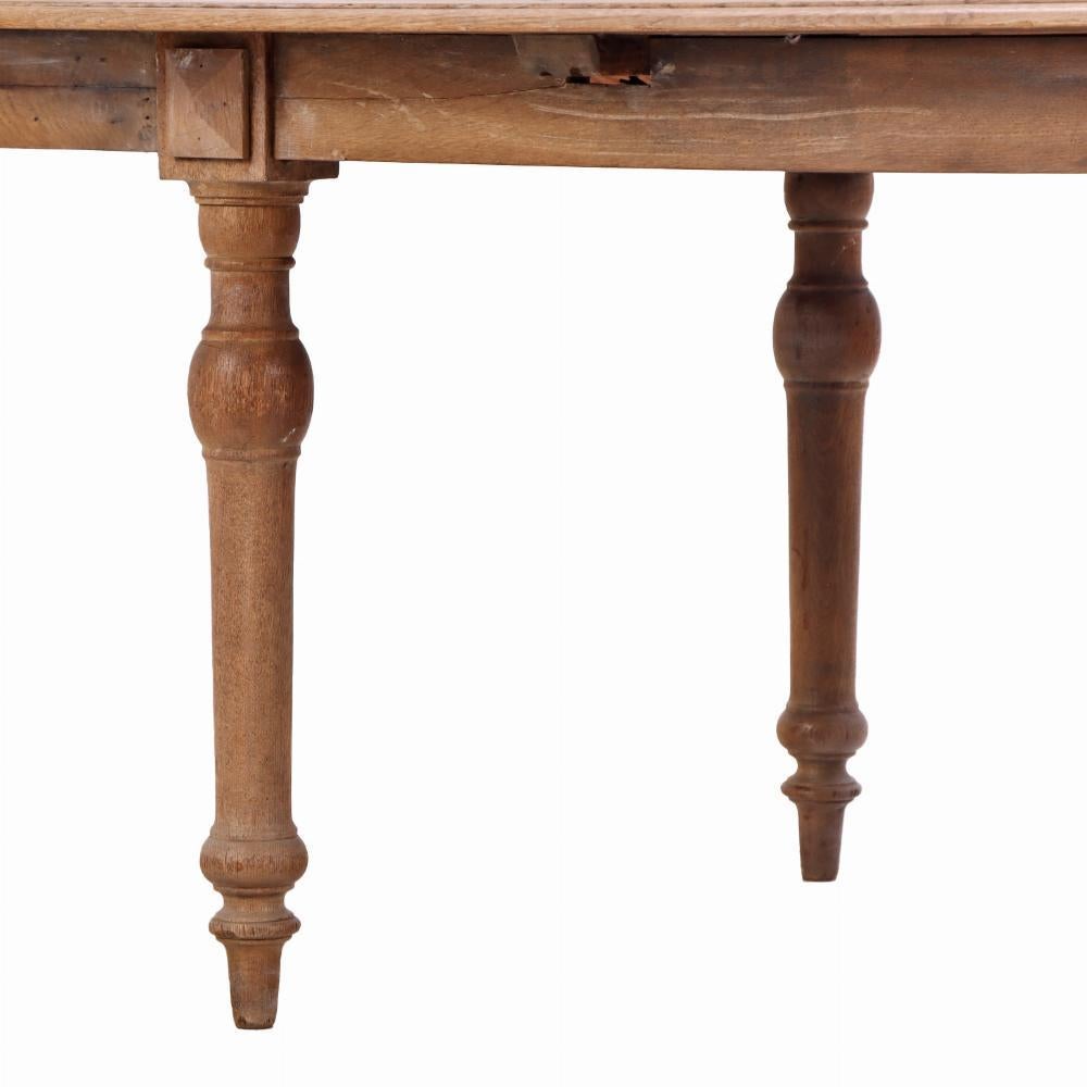 De gran tamaño, esta mesa presenta un rico veteado y una pátina envejecida en el tablero, sostenido por robustas patas torneadas unidas por un delantal de ebanistería tradicional. Con su construcción sencilla y honesta y sus proporciones