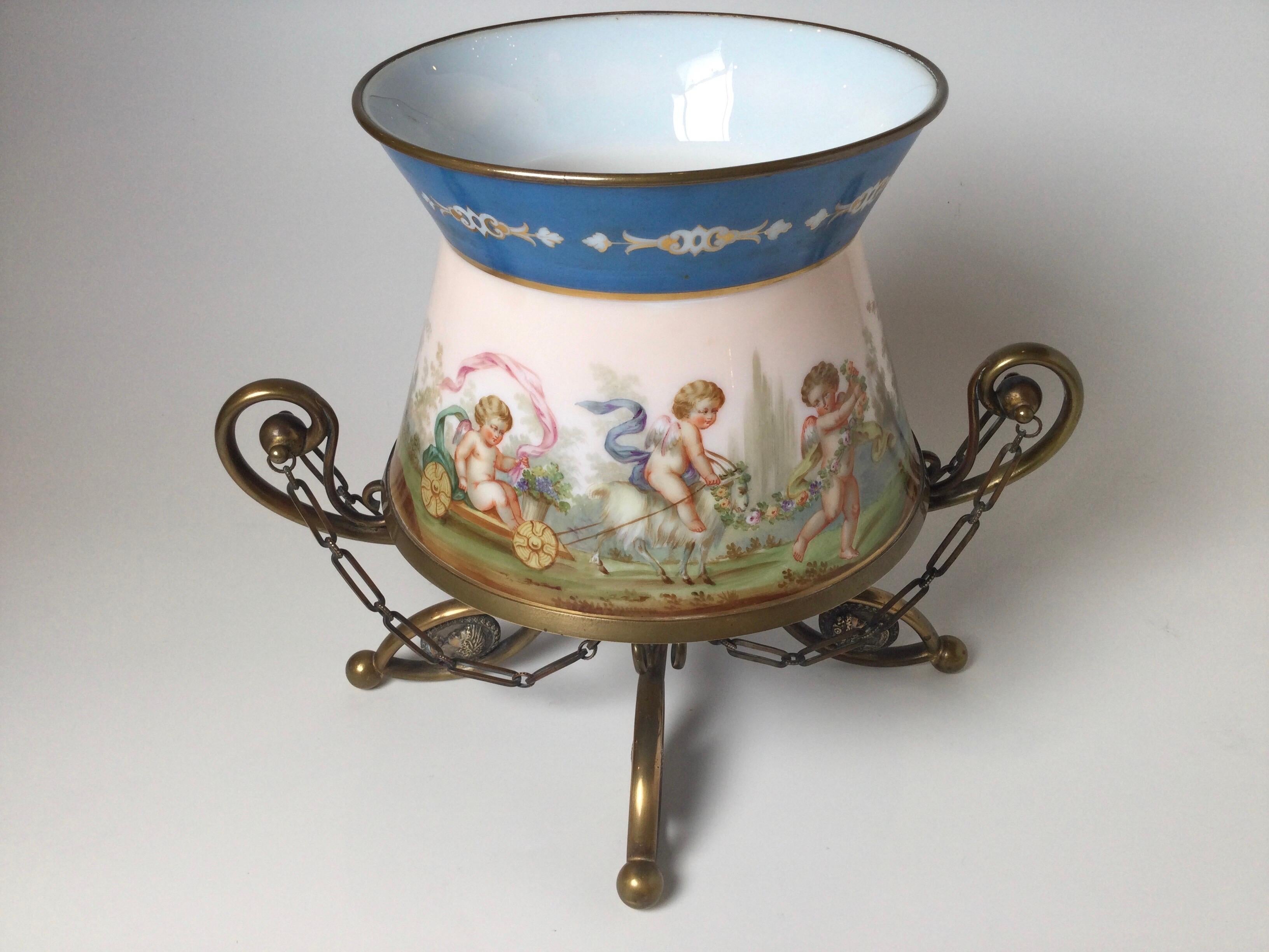 A French opaline glass hand painted center bowl depicting cupids, goats frolicing in a pastoral scene. The attached footed mount with chains in original aged bronze. The hand painted glass with Celest blue border.