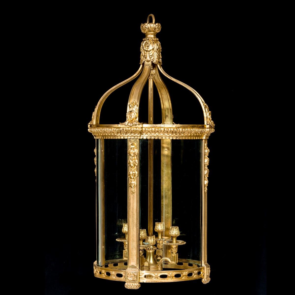 A French ormolu four-light lantern, of cylindrical form with four uprights embellished with pendant husks which curve into a central acanthus leaf terminal, the socles also in the form of acanthus buds. Circa 1880.