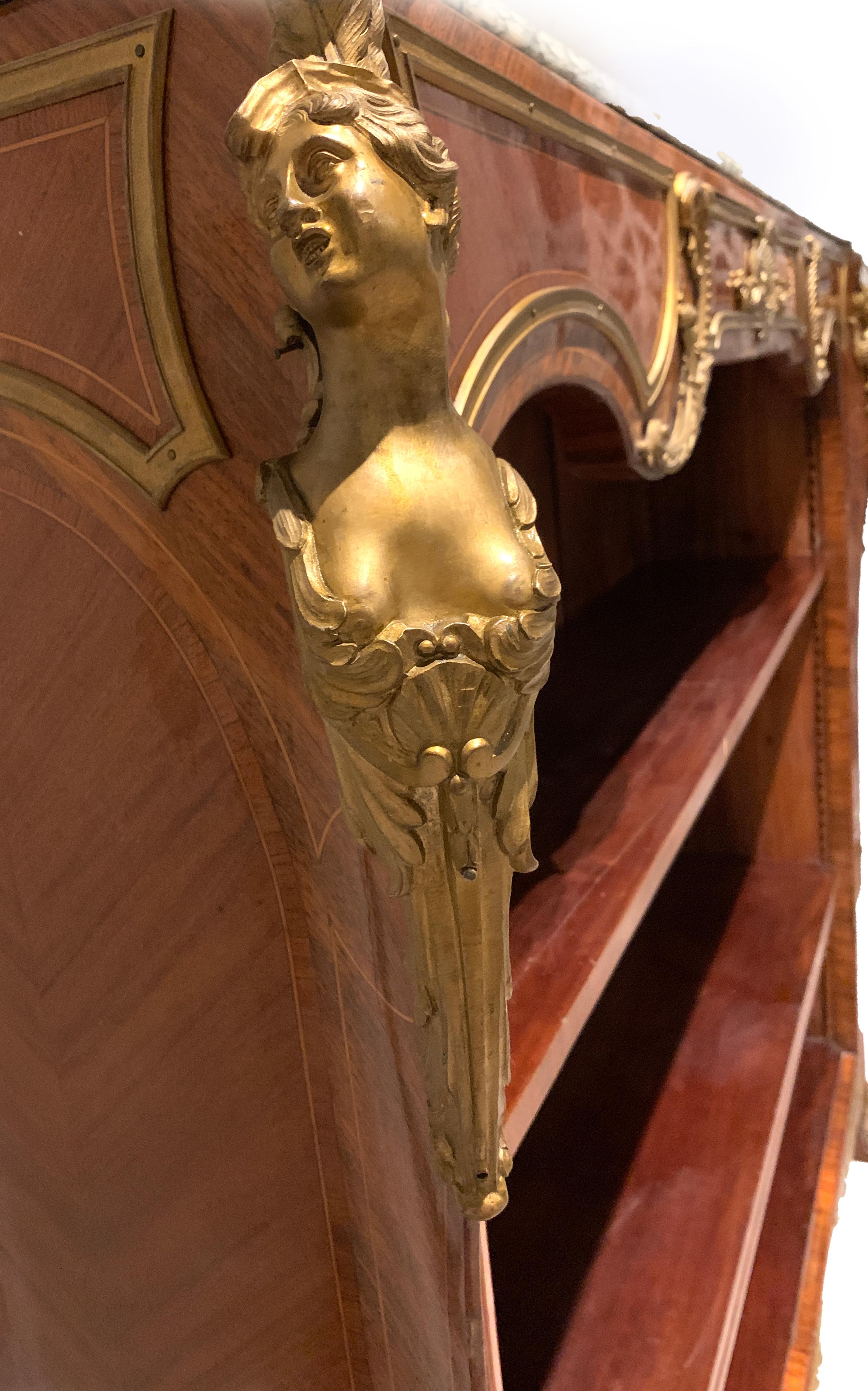 A fine French Bibliotheque with Marble top above a spreading cornice, three adjustable shelves, the angles mounted with female busts and raised on ormolu paw feet.
 
