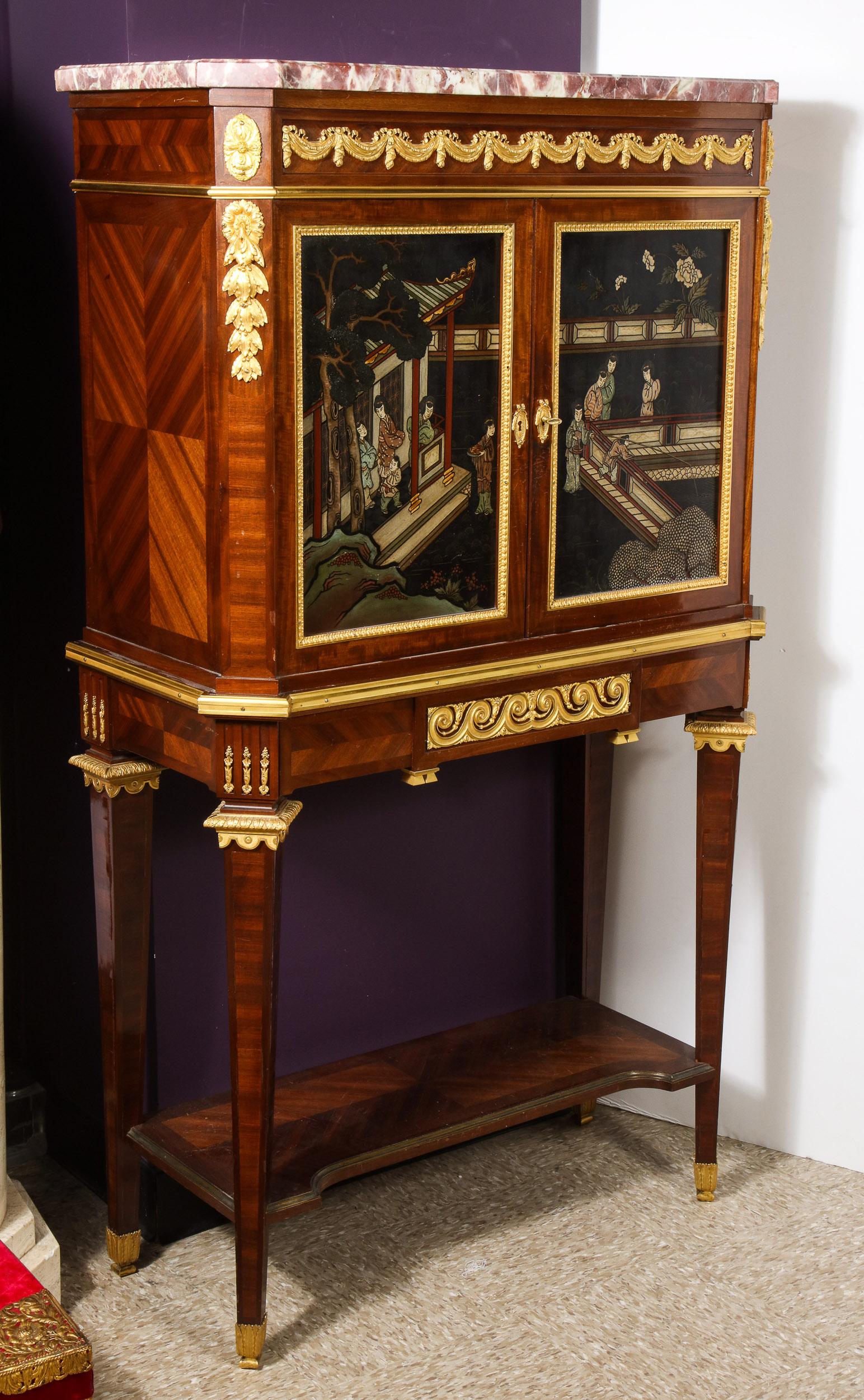 A French ormolu-mounted mahogany, satine, and Chinese coromandel lacquer cabinet by Fernand Kohl, Paris, circa 1880.

Surmounted by a rectangular marble top, opening with two doors to an interior fitted with one shelf, and mirrored glass, above a