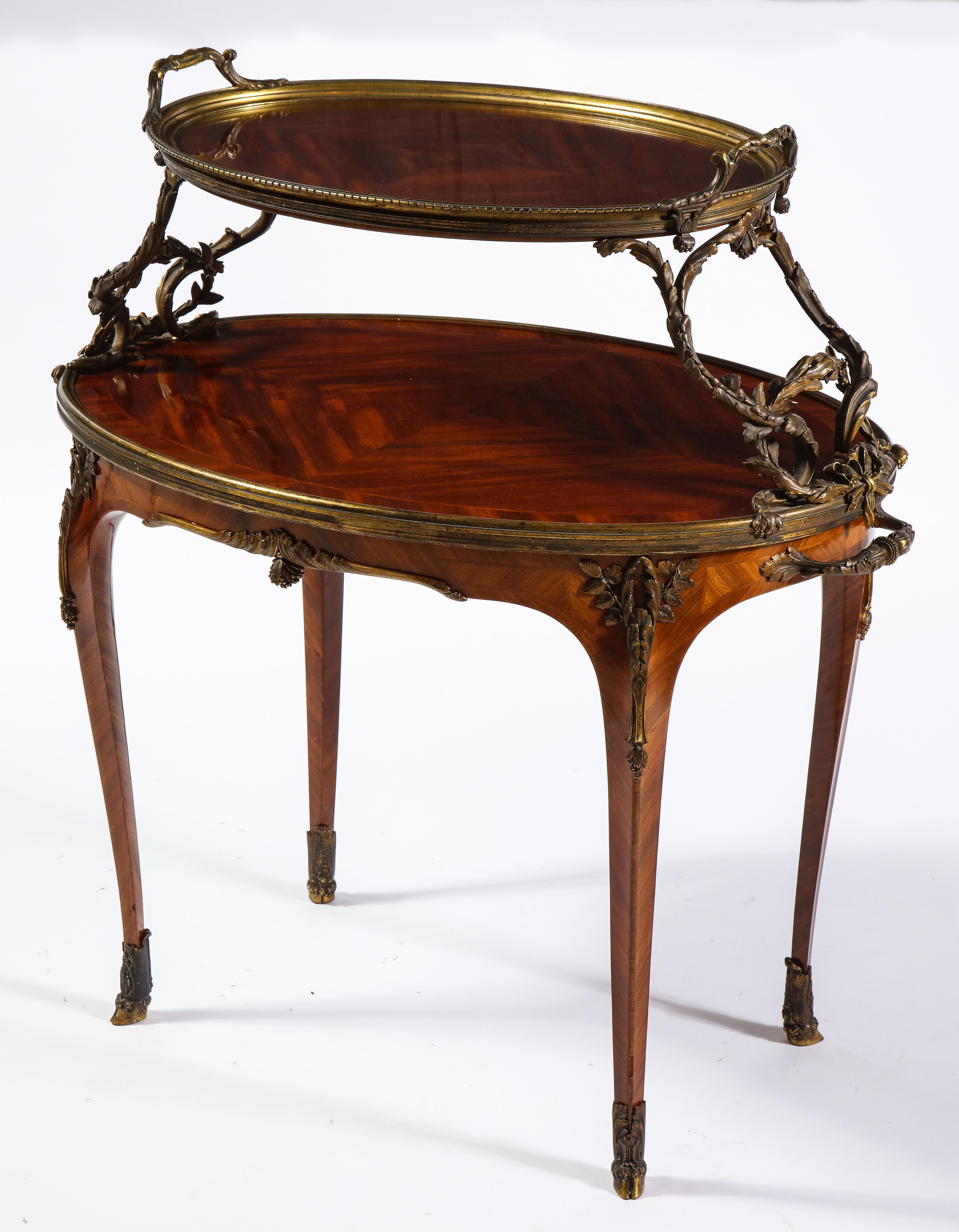 Ein fabelhafter französischer Mahagoni-Tee-Tisch im Louis-XVI-Stil des 19. Jahrhunderts mit Ormolu-Beschlägen, der Paul Sormani zugeschrieben wird. Die eiförmige obere Etage mit abnehmbarem Glastablett, das von verschlungenem Blattwerk getragen