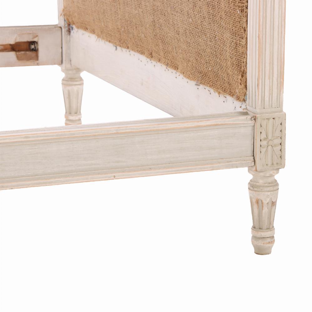 Bellamente tallada con columnas cuadradas estriadas que sostienen cabeceros y pieceros arqueados y tapizados, adornos de rosetas bloqueadas en la parte superior e inferior de cada columna, y todo ello apoyado sobre patas cónicas torneadas y