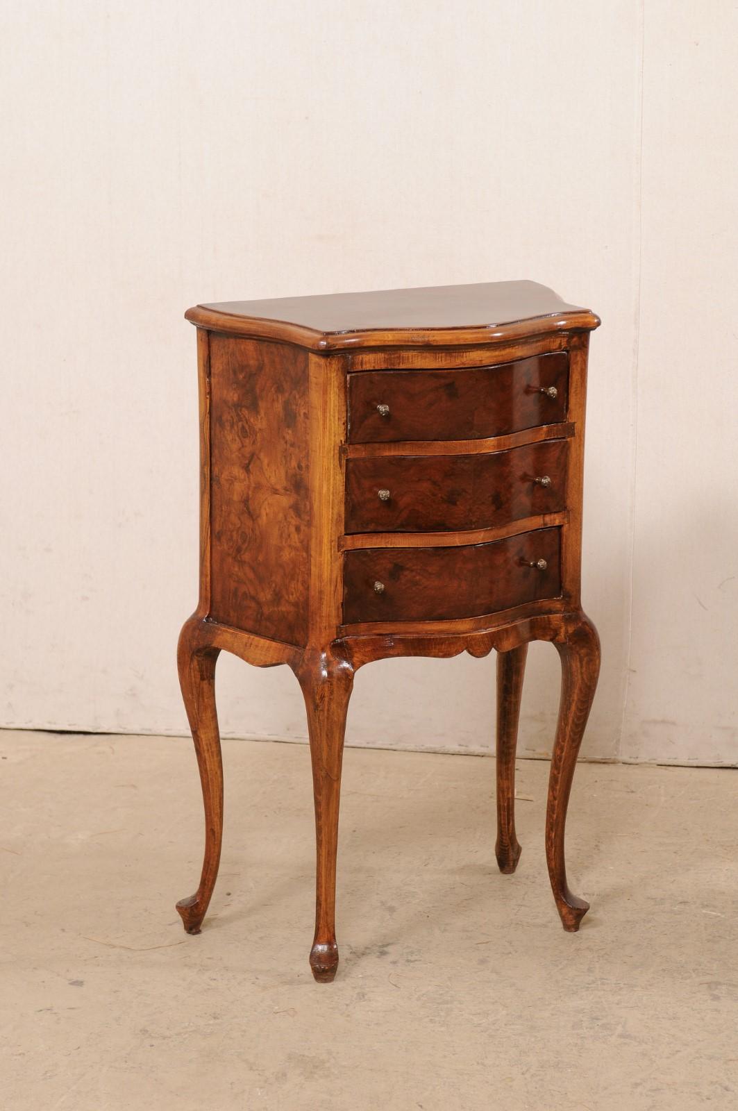 A French pair of raised three-drawer side chests from the mid-20th century. These antique commodes from France each feature a graceful serpentine shaped front and curvy sides, with rear being spread wider than frontside. The fruit wood is