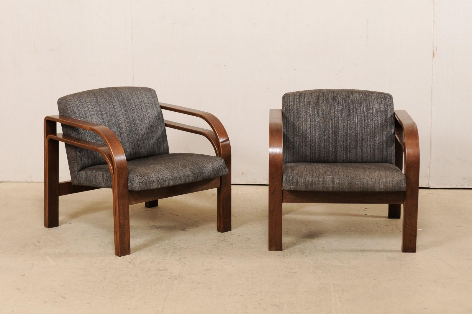 A French pair of bent-wood double armchairs, with upholstered seat and back, from the mid-20th century. This midcentury pair of occasional chairs from France each feature a pair of beautifully bowed, bent-wood arms a each side, one atop the other,