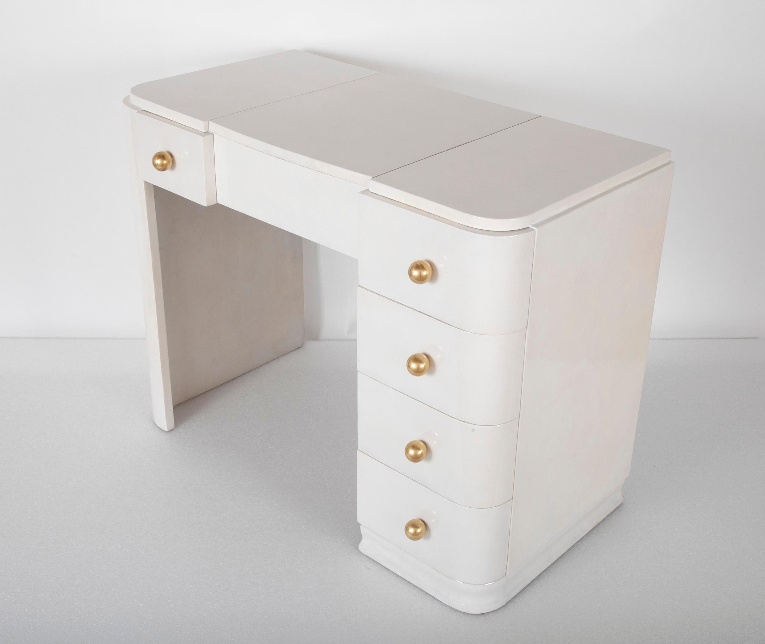 A Parchment dressing table finished on 4 sides. Having a interior compartment that is reached by raising the central section on top of the desk. See images for illustration.