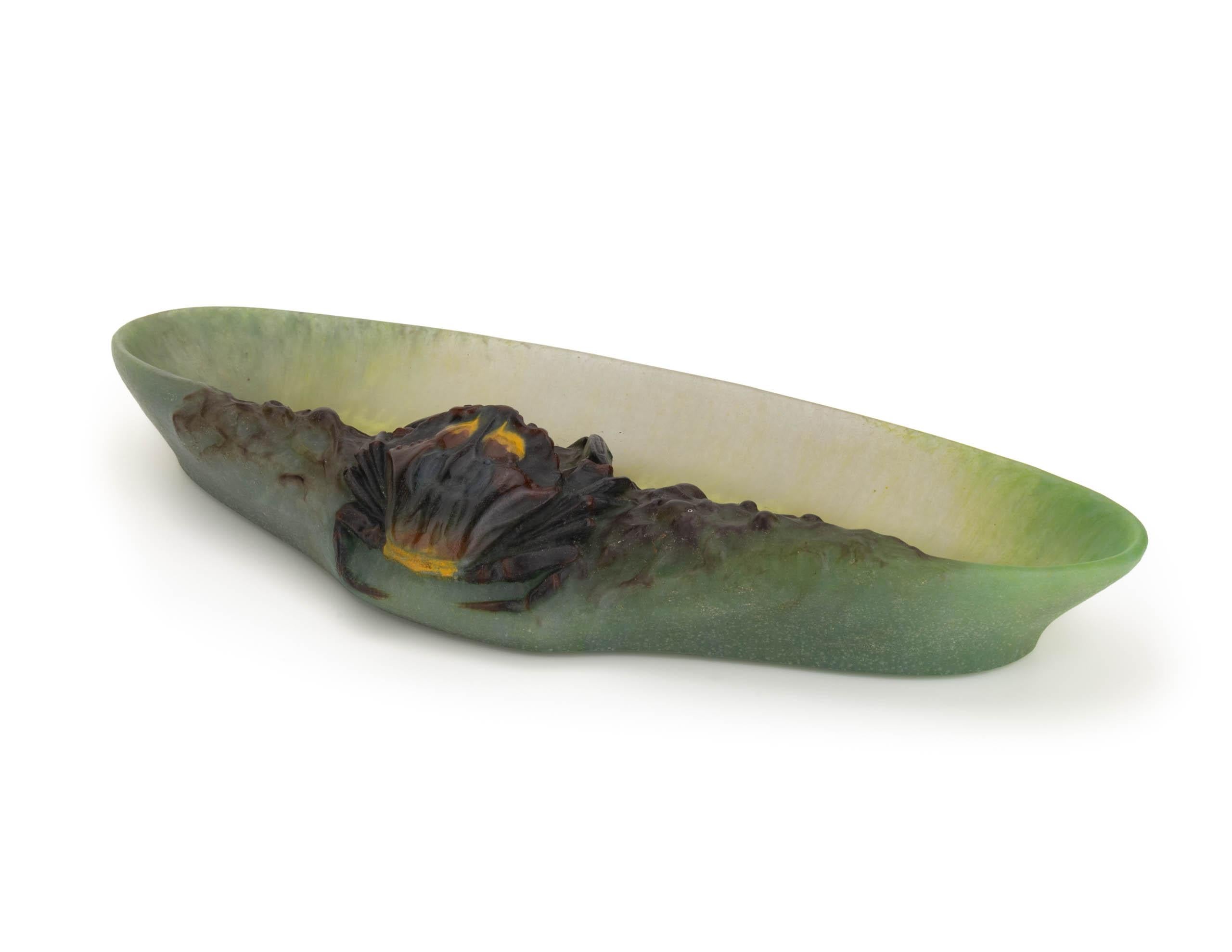 This plumier manufactured by Amalric Walter and Henri Bergé is executed in the theme of marine animals. The elongated bowl was obtained in several green and yellow swirling hues of color through the mixing and addition of glass powders after which