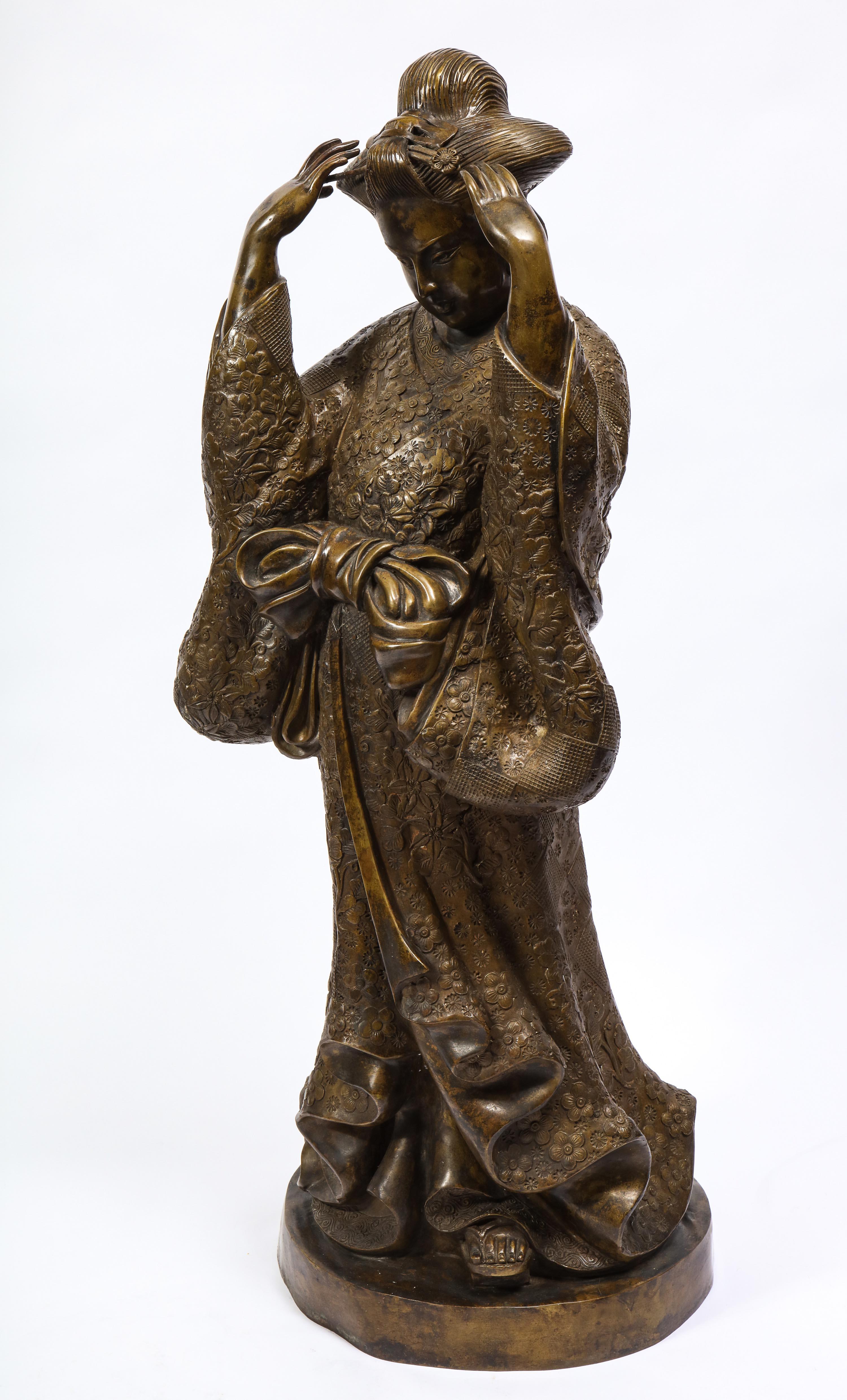 A beautiful French patinated bronze figure of a standing Japanese geisha in a traditional kimono with an obi. This geisha is exceptionally cast with immense detail. Starting from the head, the elaborate Yakko-shimada hairstyle with gorgeous kanzashi